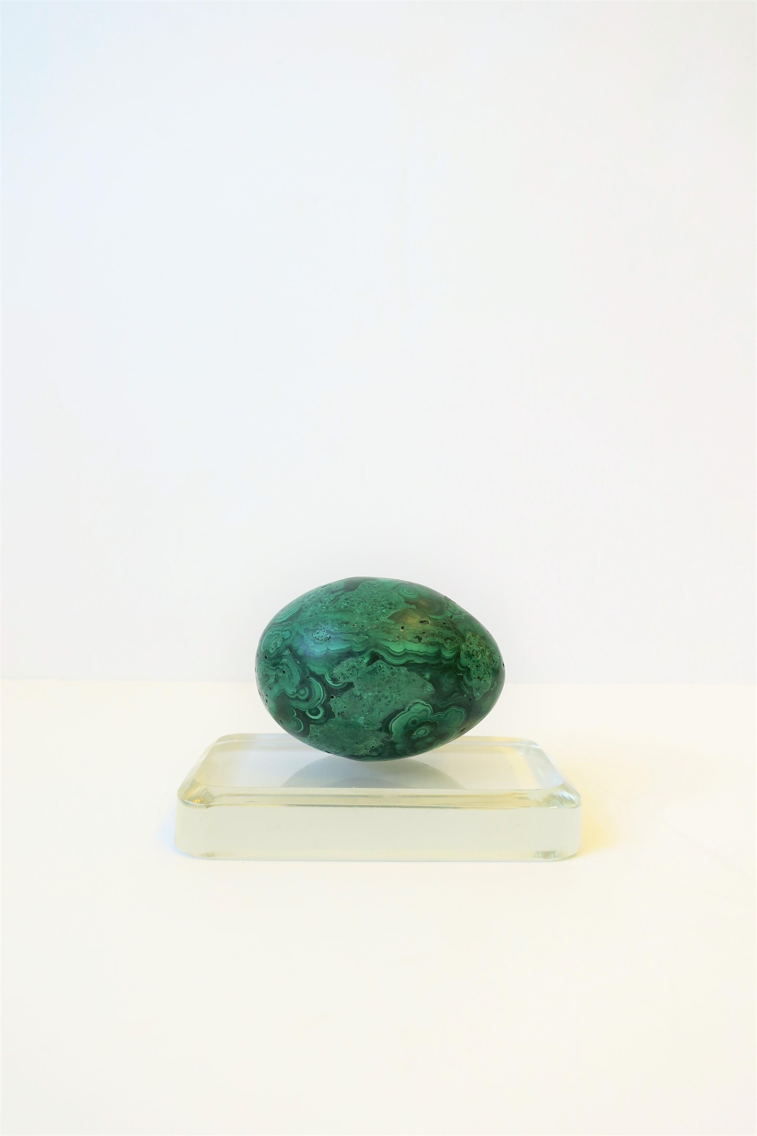 A beautiful and substantial green malachite decorative object sculpture piece in an egg shape form on a clear crystal glass plinth base. 

Malachite measures: 2