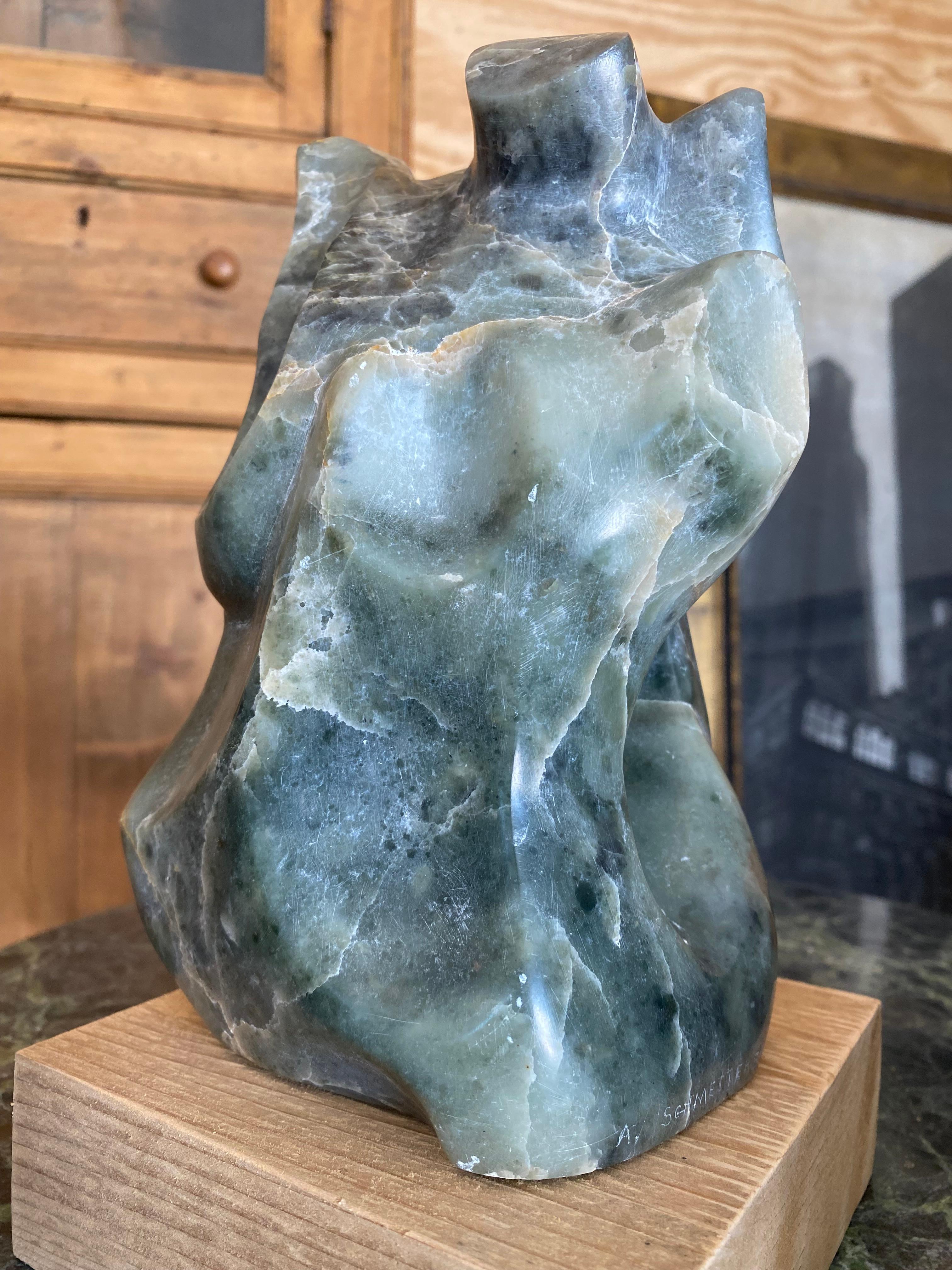 Una meravigliosa scultura in marmo verde scolpito, dalla forma astratta e antropomorfa con contorni stilizzati. La forma suggerisce una figura umana senza definire tratti chiari, dando un'impressione da galleria. I toni verdi naturali e le venature