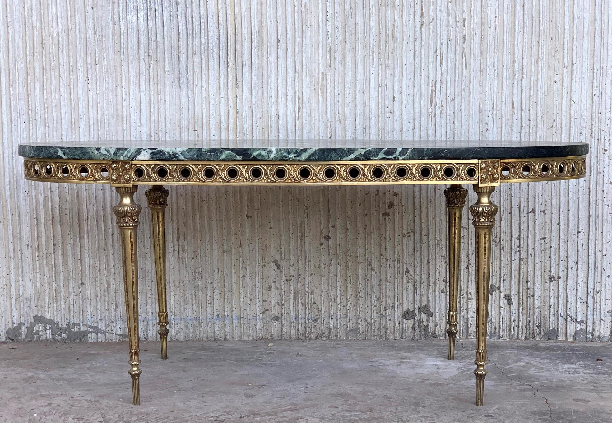 Hollywood Regency style coffee table. Green solid marble tops rest on four sculptural bronze legs.


  