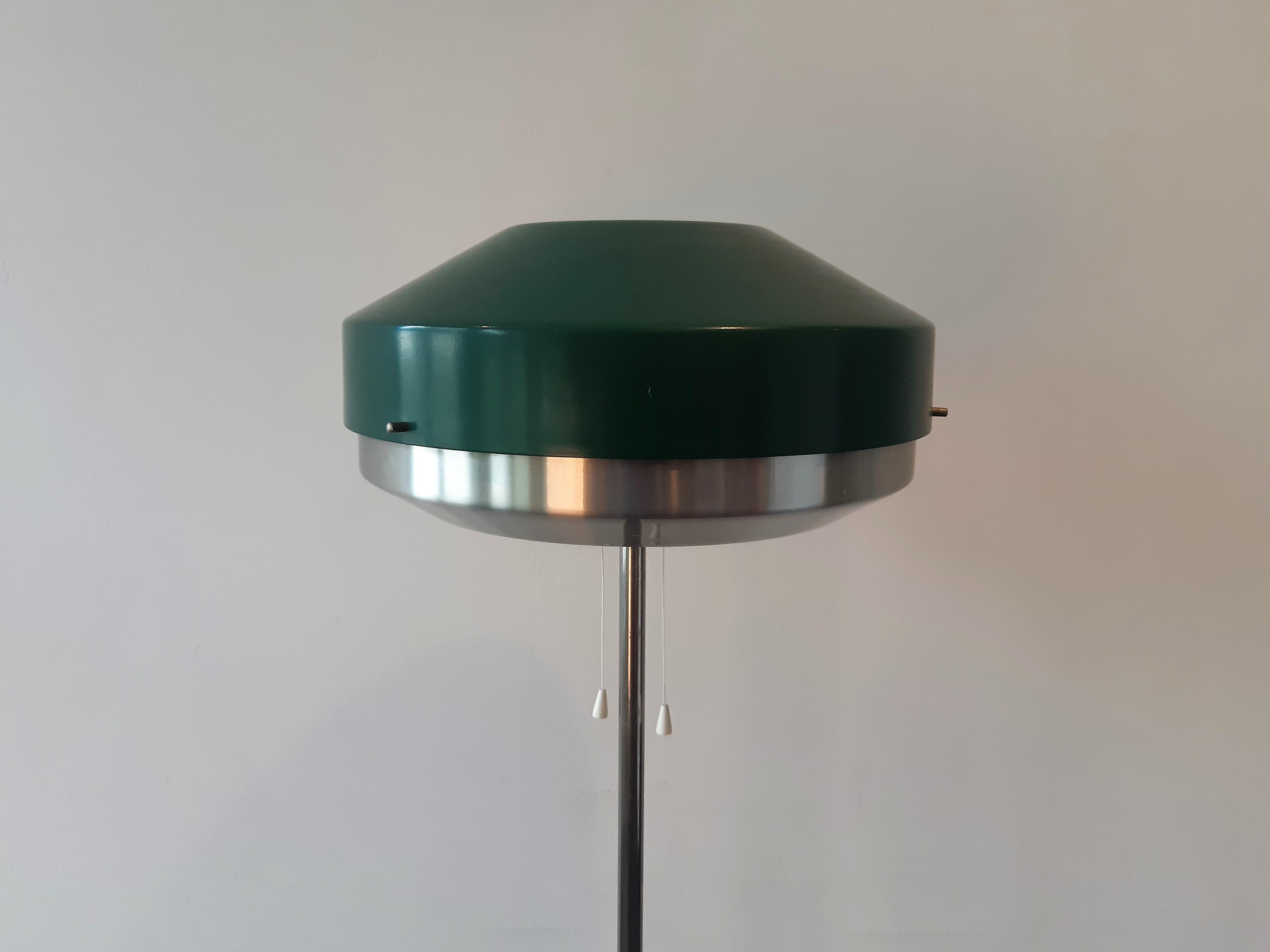 This stunning floor lamp was designed by Willem Hagoort for Hagoort Lamps in the 1960's. It has a metal tripod base with a green metal and matte aluminum shade. It has 1 upward light and three separate lights inside the lampshade; you can switch the