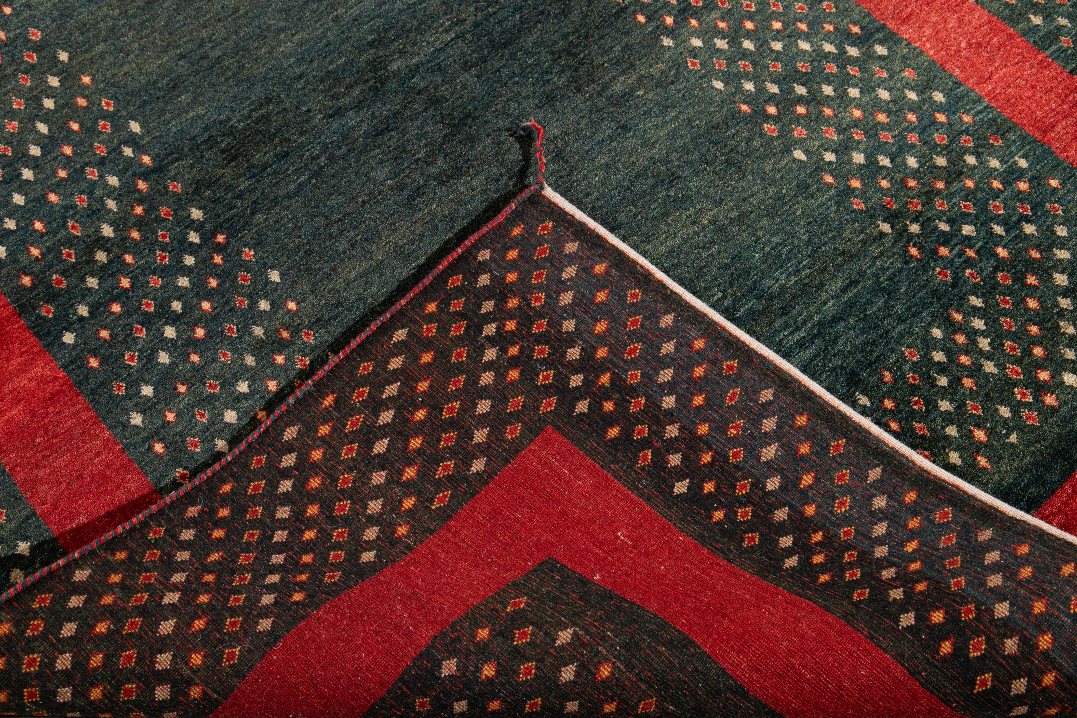 Schöne zeitgenössische persische Gabbeh handgeknüpfte Wolle Teppich mit einem grünen Feld. Dieser Gabbeh-Teppich hat einen roten Rahmen mit einem herrlichen geometrischen Rautenmuster.

Dieser Teppich misst 5' x 7' 2