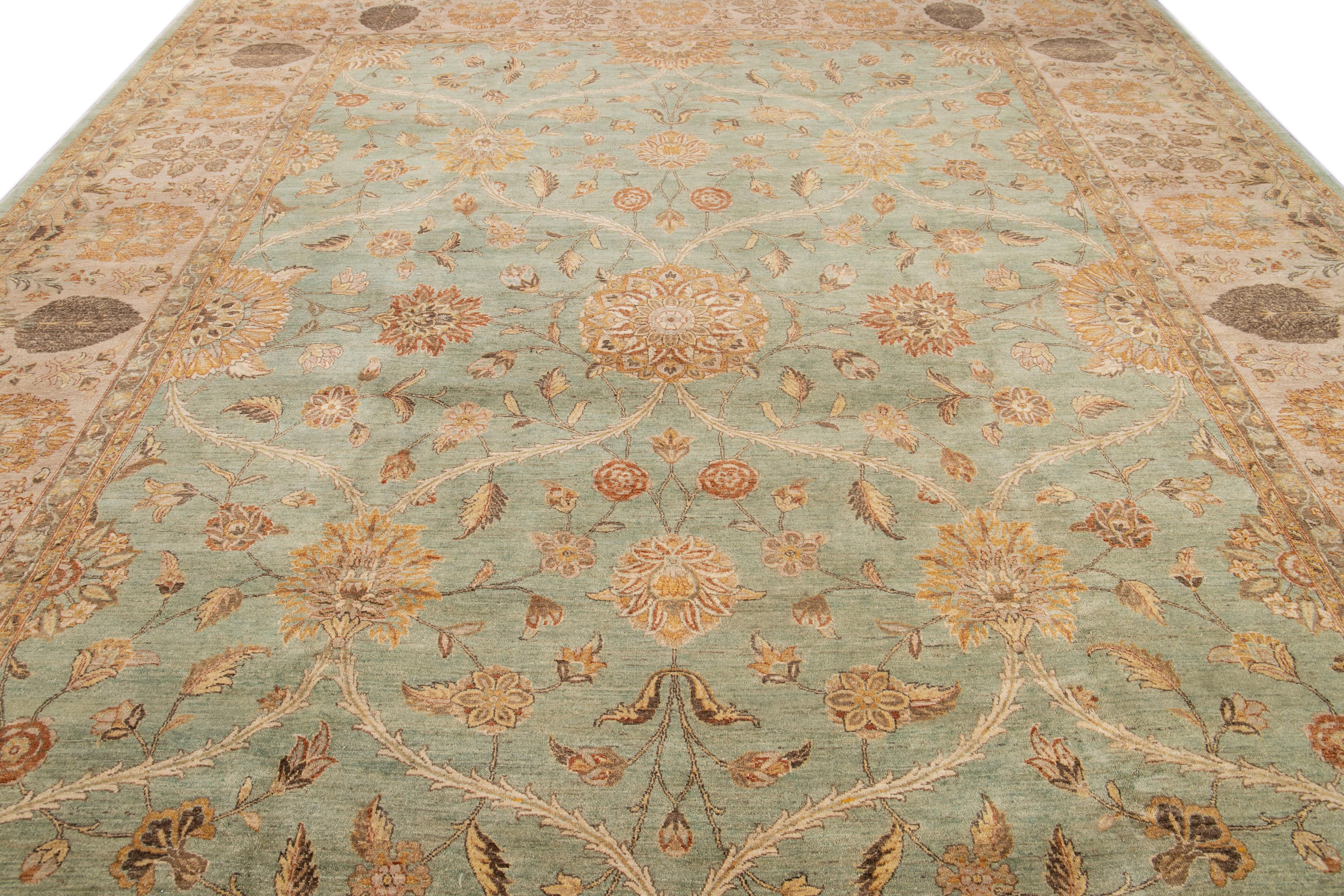Ce tapis en laine de style Tabriz arbore un splendide motif floral complexe, présenté de manière classique dans un champ de couleur verte, avec des accents dorés, beiges et bruns.

Ce tapis mesure 11'10