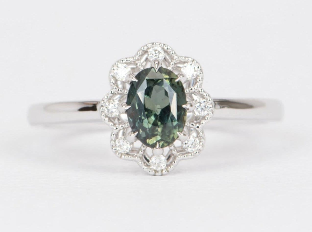 ♥ A beautiful bluish green Montana sapphire is set in the center and flanked by a milgrained scallop halo with white brilliant diamonds
♥ The setting measures 10.2 mm in length, 8.8 mm in width, and sits 5.3 mm tall

♥ Solid 14K White Gold
♥ Band