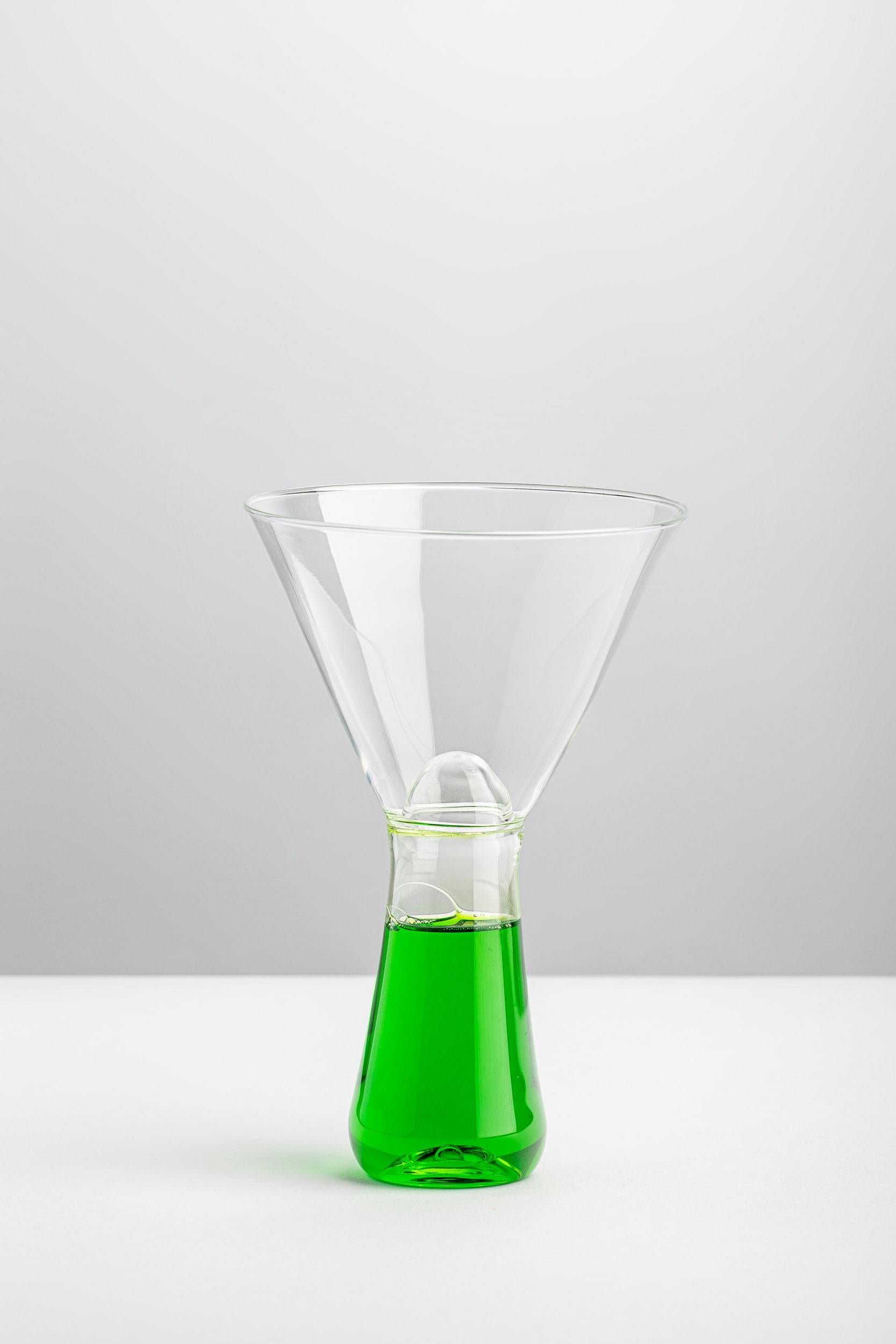 The conical stem filled with colored detergent seems to invade the chalice cup at every sip of our aperitif. Sculpturally beautiful, VELENI’s Martini Glass MG-30g plays on the dichotomy between attraction and repulsion: every time we have a drink we