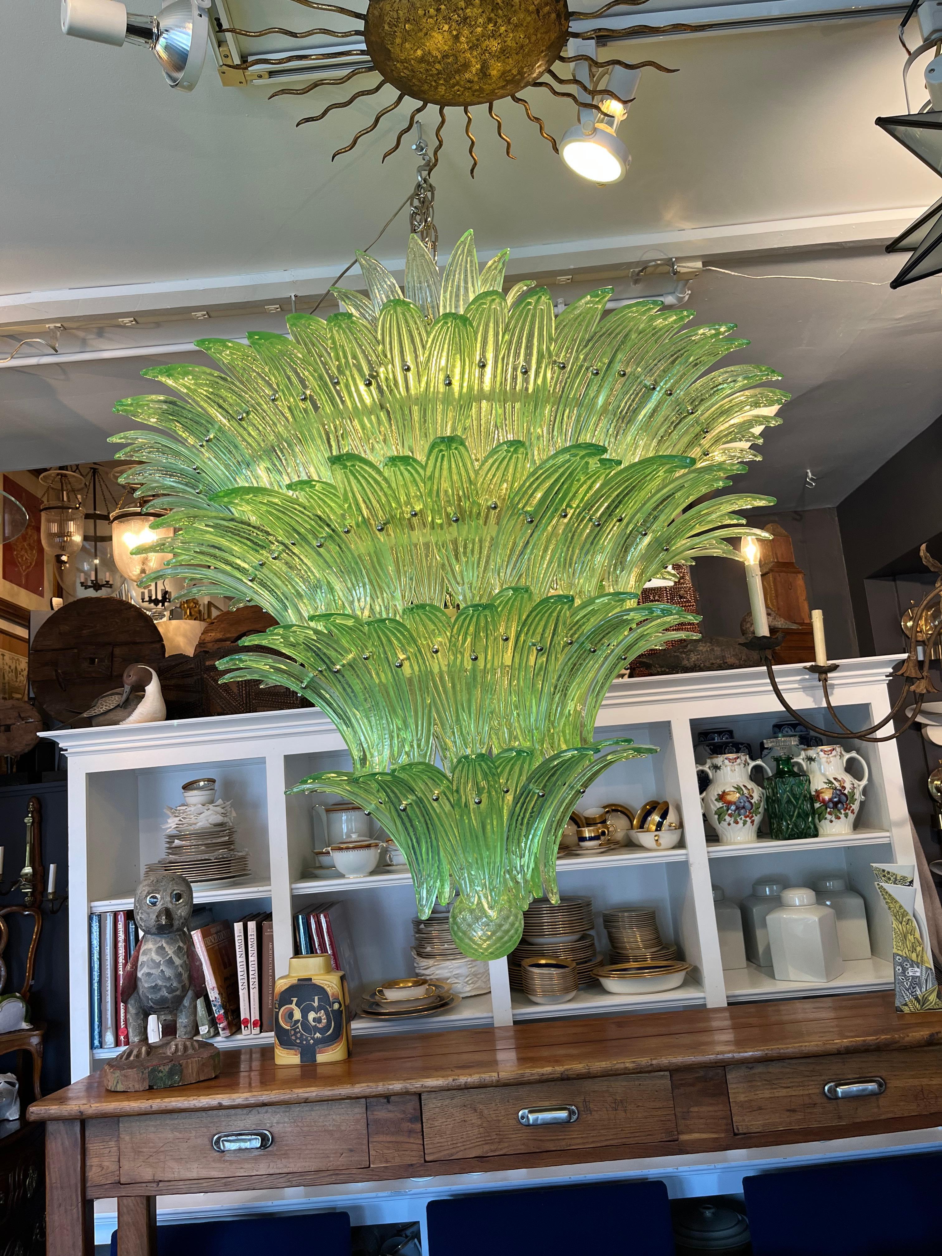 A must have for a magnificent focal point! This chandelier features more than 150 handmade textured green Murano glass palmettes all resting on a structurally beautiful five tier handmade metal skeleton. The glass palmettes are individually placed