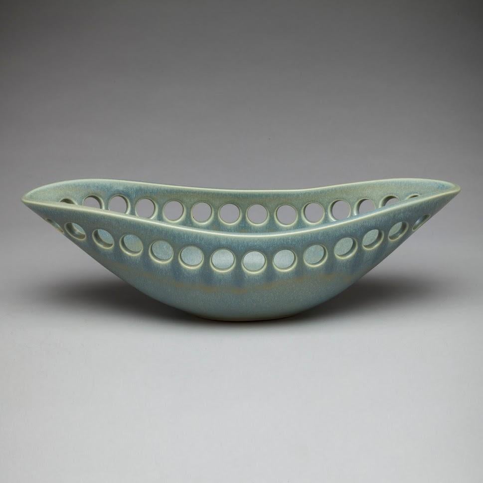 Inspired by organic contemporary design, this pierced oblong bowl is wheel thrown, distorted and hand pierced stoneware with a satin glaze. Small holes are created when the clay is still wet and then each hole is painstakingly enlarged and smoothed
