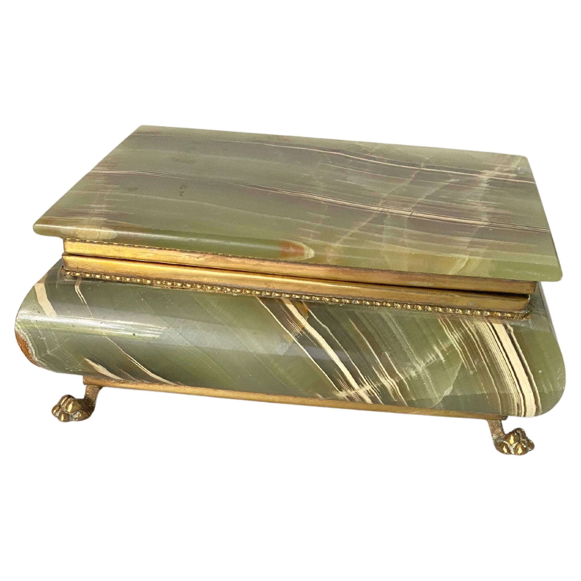 It is a box in Onyx, with the structures in Brass, as well as the feet of the box. The interior is lined with red felt. It is a jewelry box, which was made in Italy in the 1950s. It is very heavy. Green in color with Veinings of different other