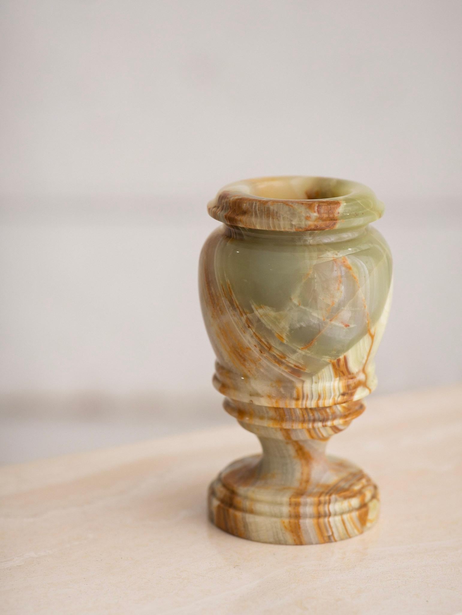 Solid onyx vase. Lovely veining and color detail from greens to beiges and browns.