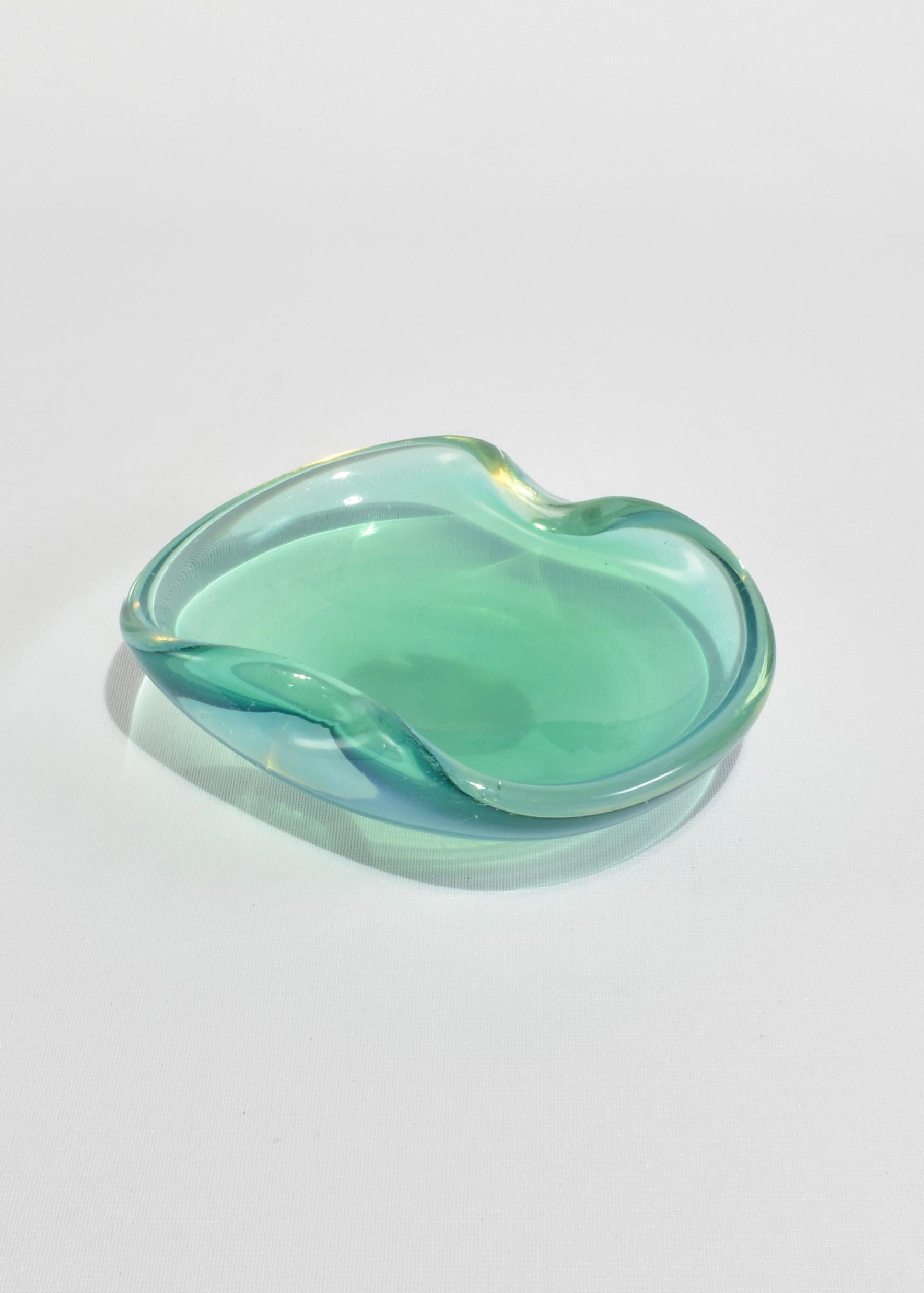 Splendida ciotola in vetro verde opalescente. Perfetto per custodire i gioielli, per far parte di un arredo da tavolo o come contenitore di piccoli tesori. Prodotto in Italia.