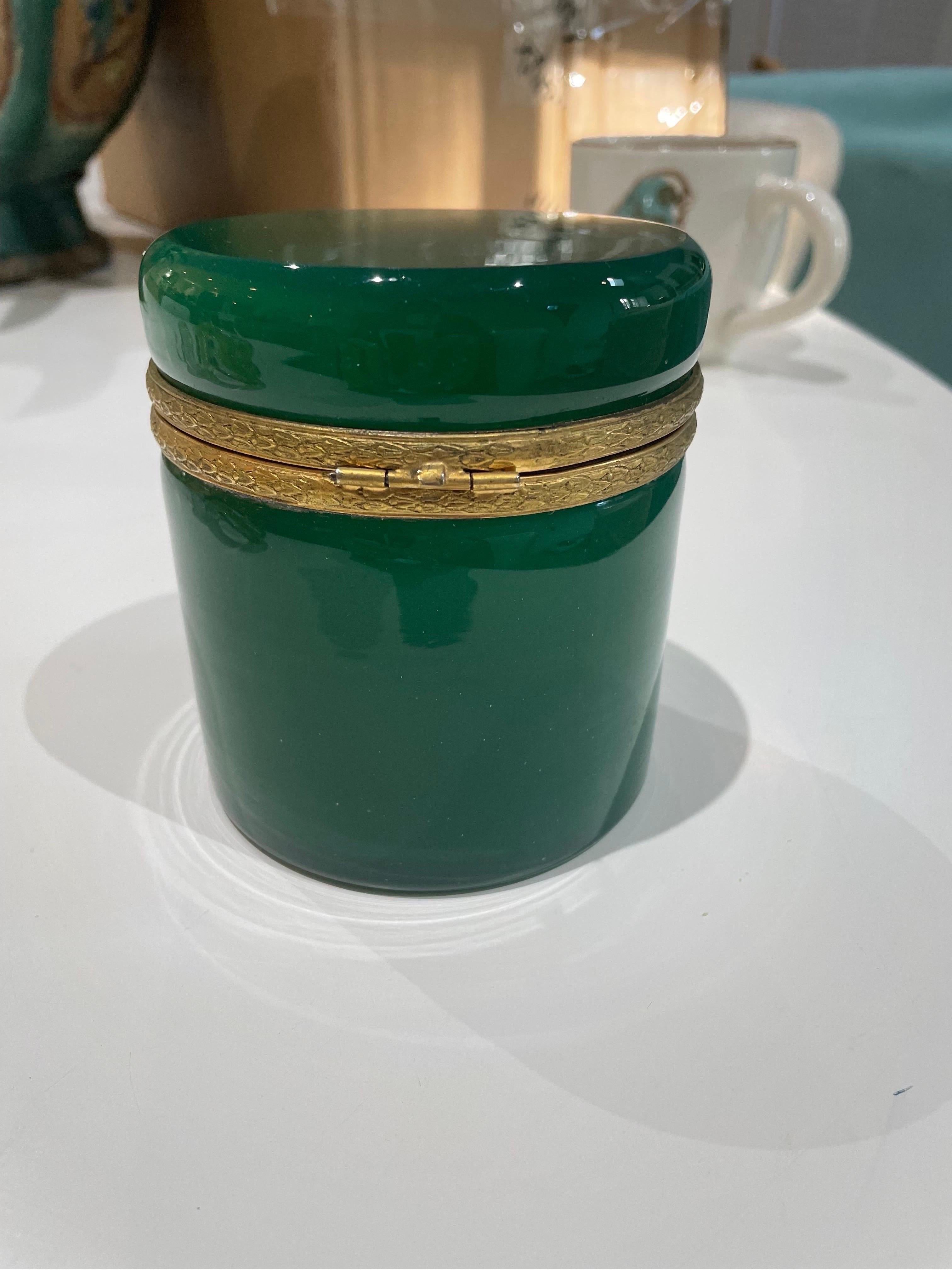 This is a vintage emerald green colored opaline jar with gold ormolou probably from 1970s.
