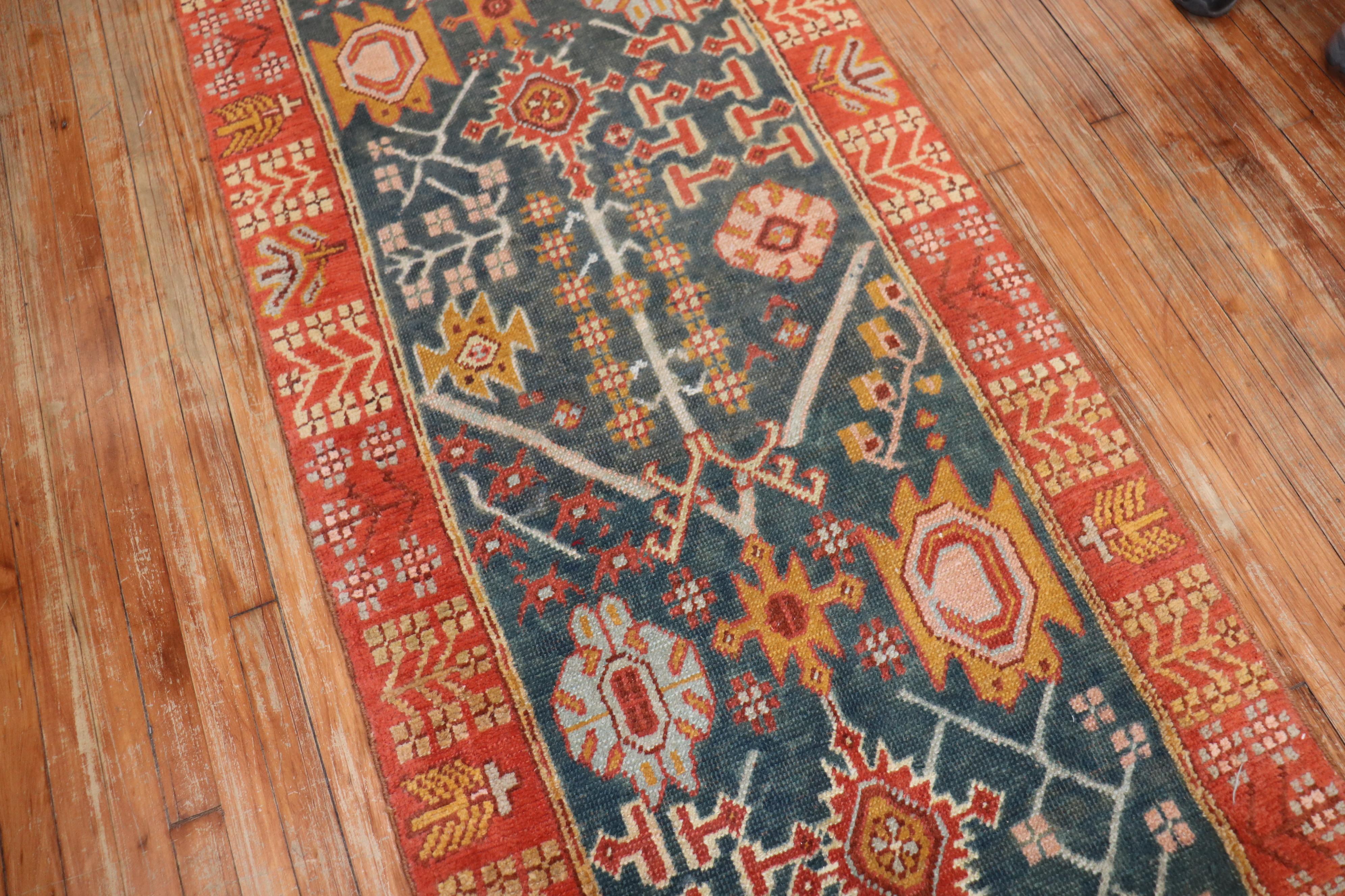 An early 20th-century antique Oushak runner in green and orangy red tones.

Measures: 3' x 15'.