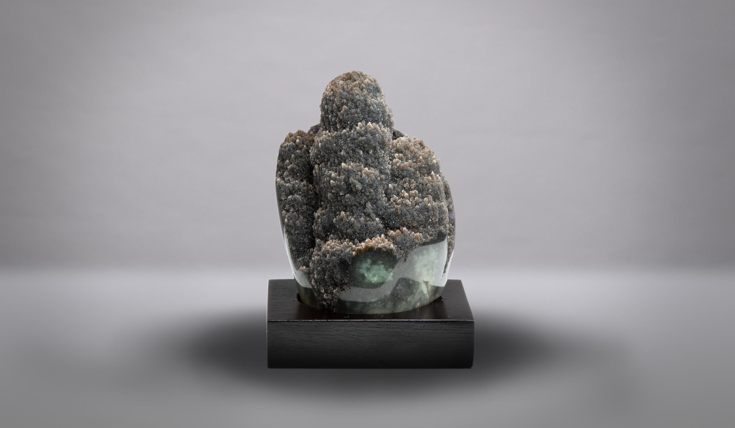 A wonderful display piece showing a prominent thick stalactite at the centre,
covered with glass-like green-brown druzy quartz. The lower border
polished to reveal a wonderful sea green celadonite “shell” belonging to
the original geode.

This piece
