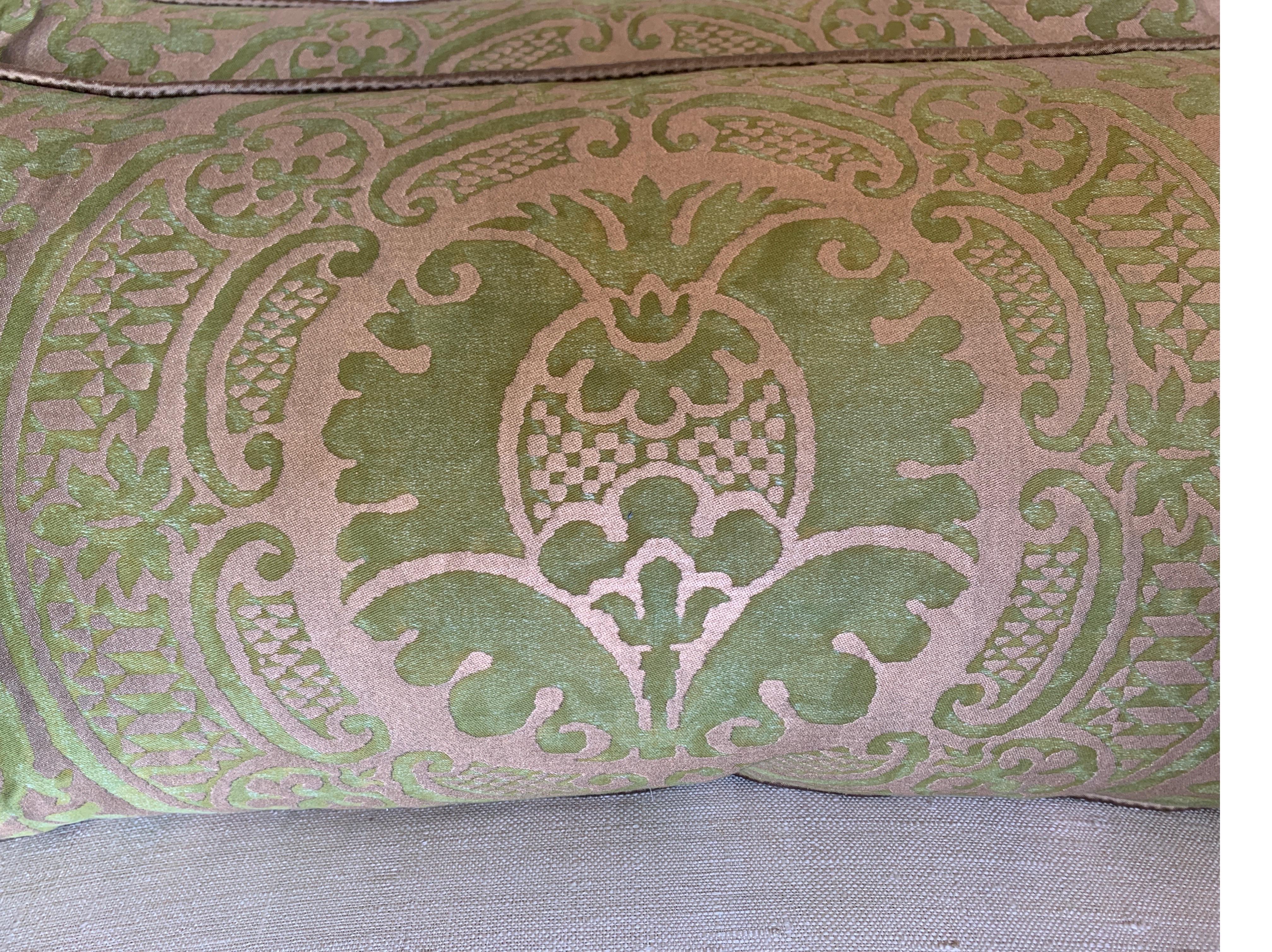 Pair of custom pillows made with Italian green and gold stenciled Fortuny fronts in the Orsini pattern and gold silk backs. Self cording, down filled inserts, sewn closed.