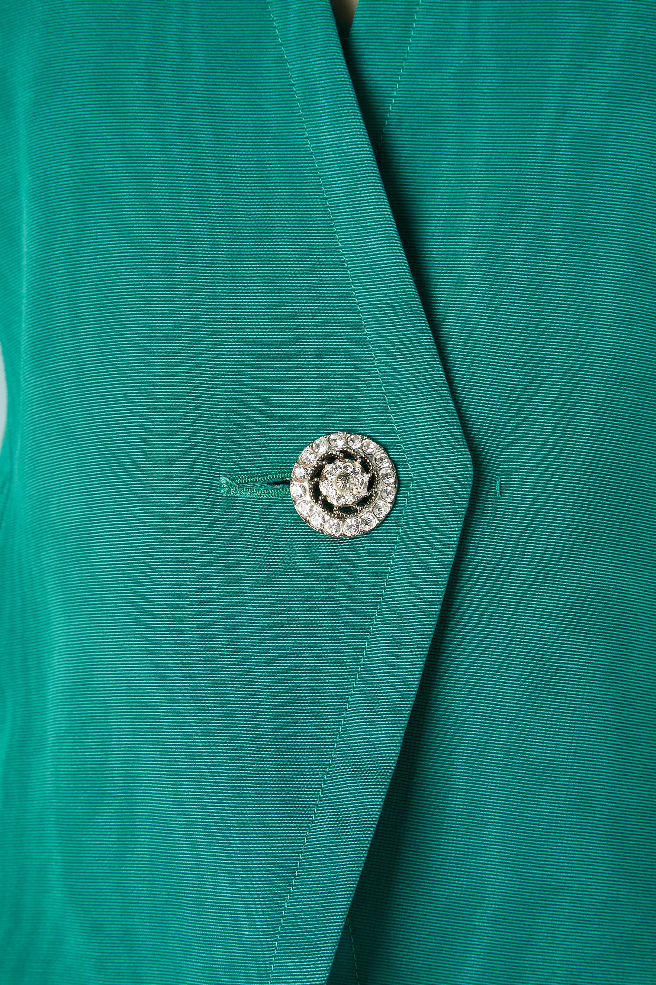 Jupe de soirée Ottoman et Moire verte  avec des boutons en strass. Pad d'épaule. 2 crochets et œillets au milieu du devant pour aider à maintenir la veste fermée : 53% coton, 47% rayonne. Composition de la doublure : 55% acétate, 45% Cupro 
TAILLE :