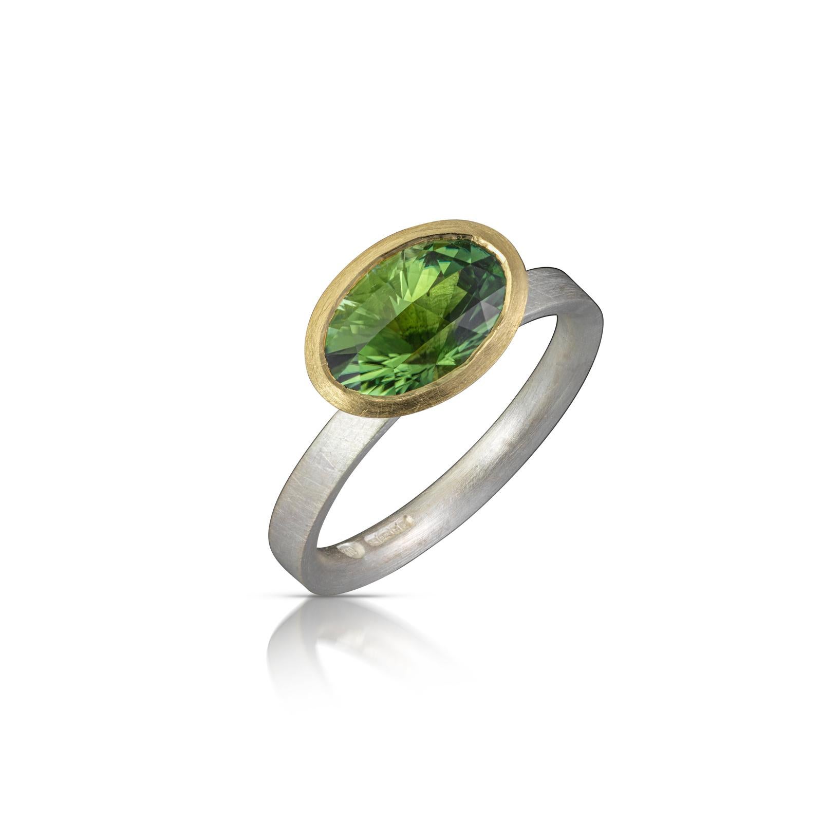 Bright green faceted tourmaline engagement or statement ring. The stone is set in 18ct yellow gold on an inverted D section sterling silver band.


Item Details
- Oval green tourmaline 2.50cts, hand cut and polished by Mark Nuell in a Long &