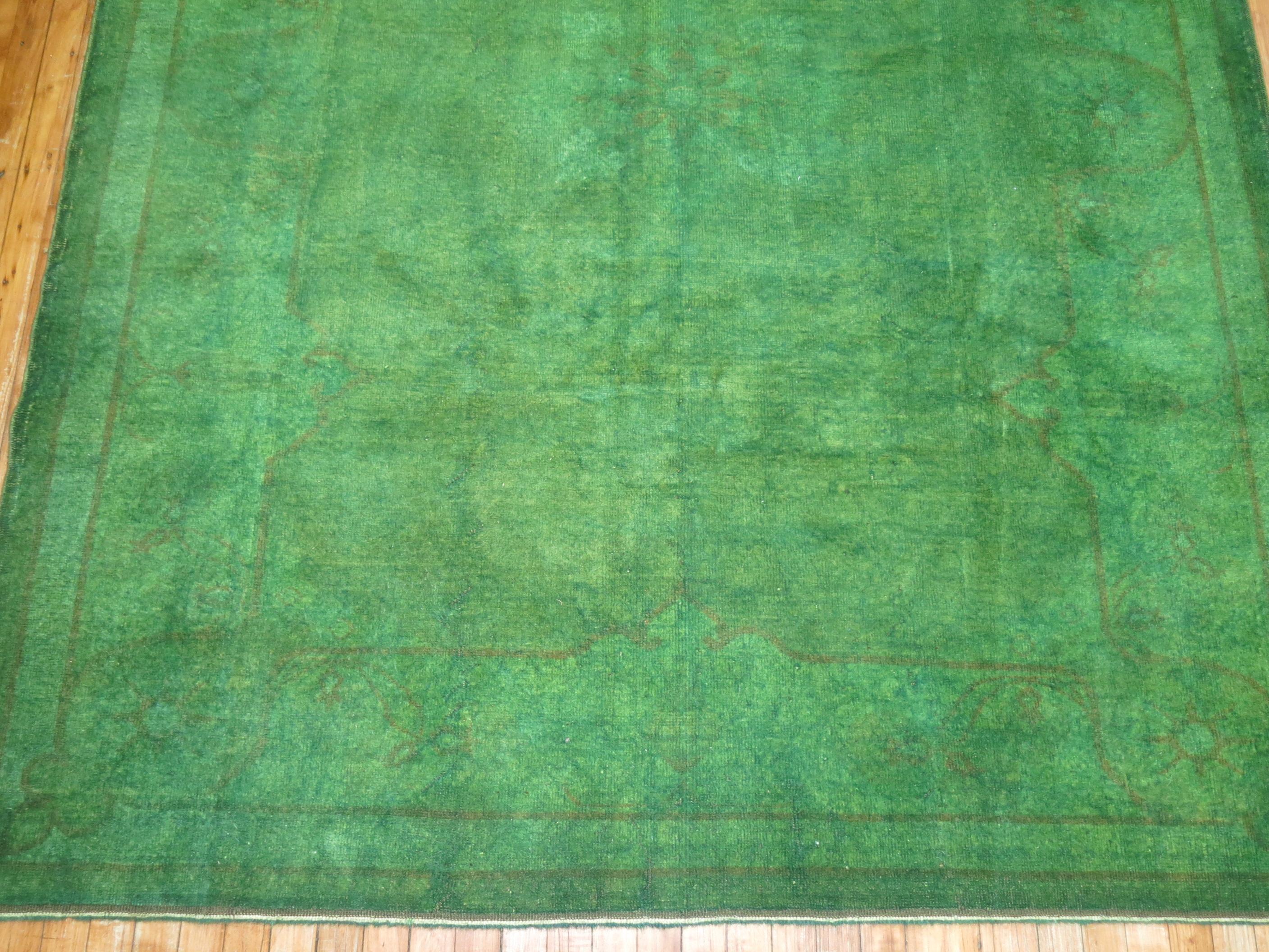 Vintage Turkish rug that has been over-dyed in green to give it a beautiful, subdued, and ethereal look. The border can still be seen, the open field design is still visible. Measures: 6'5