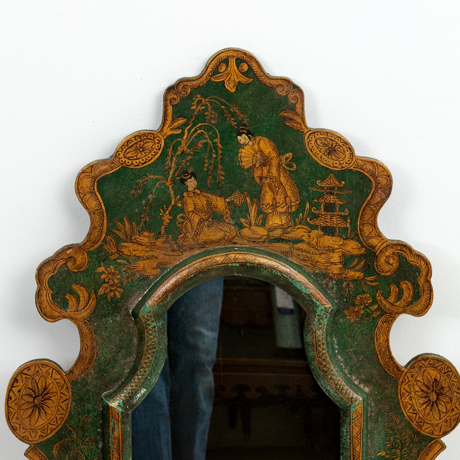 Green painted mirror with original glass that features Chinese style figures and floral motifs, circa 19th century. Please note of wear consistent with age including some green paint loss.