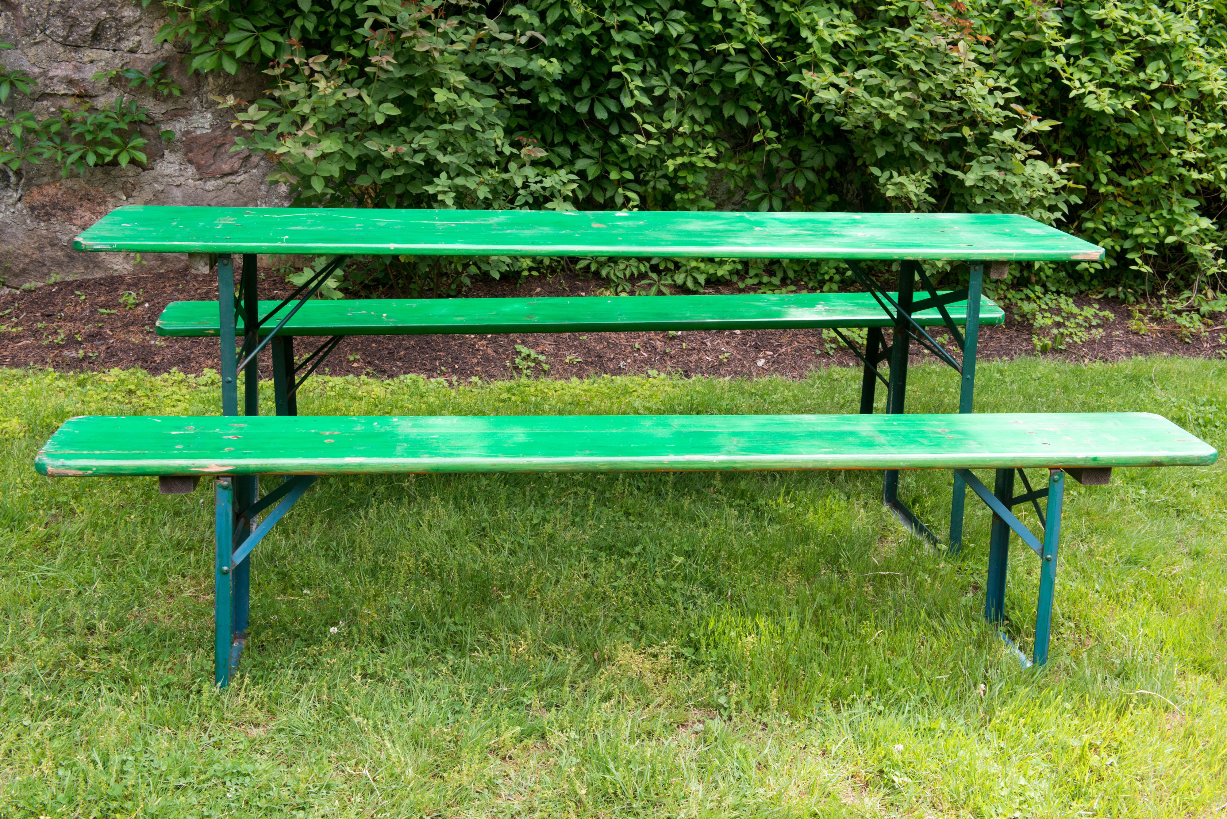 German beer garden green painted wood folding table with two wood folding benches. Sturdy and well made wood surfaces and metal folding legs. Folding 
mechanism is great German engineering. Benches are 86.5