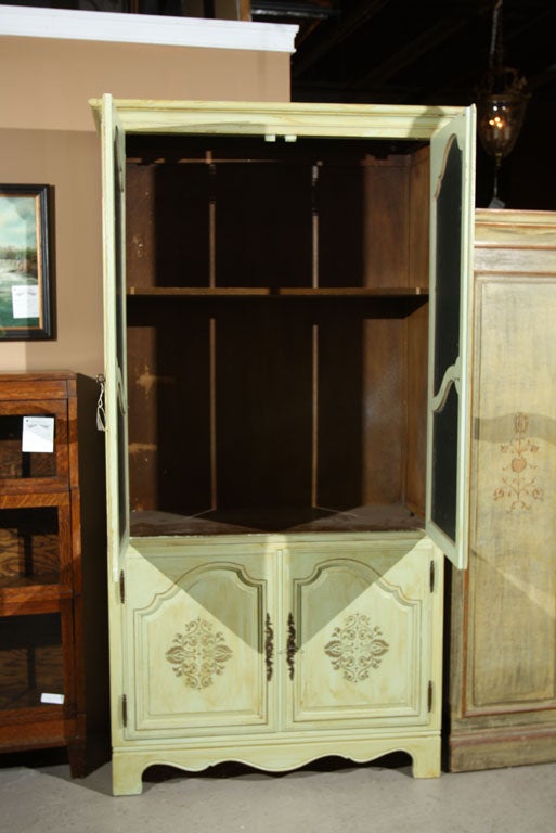 Green distressed painted armoire by Baker, each with two glass doors over a two-door cabinet, standing on splayed bracket feet. Each bearing the Baker Furniture Company on the reverse. Oak interiors.