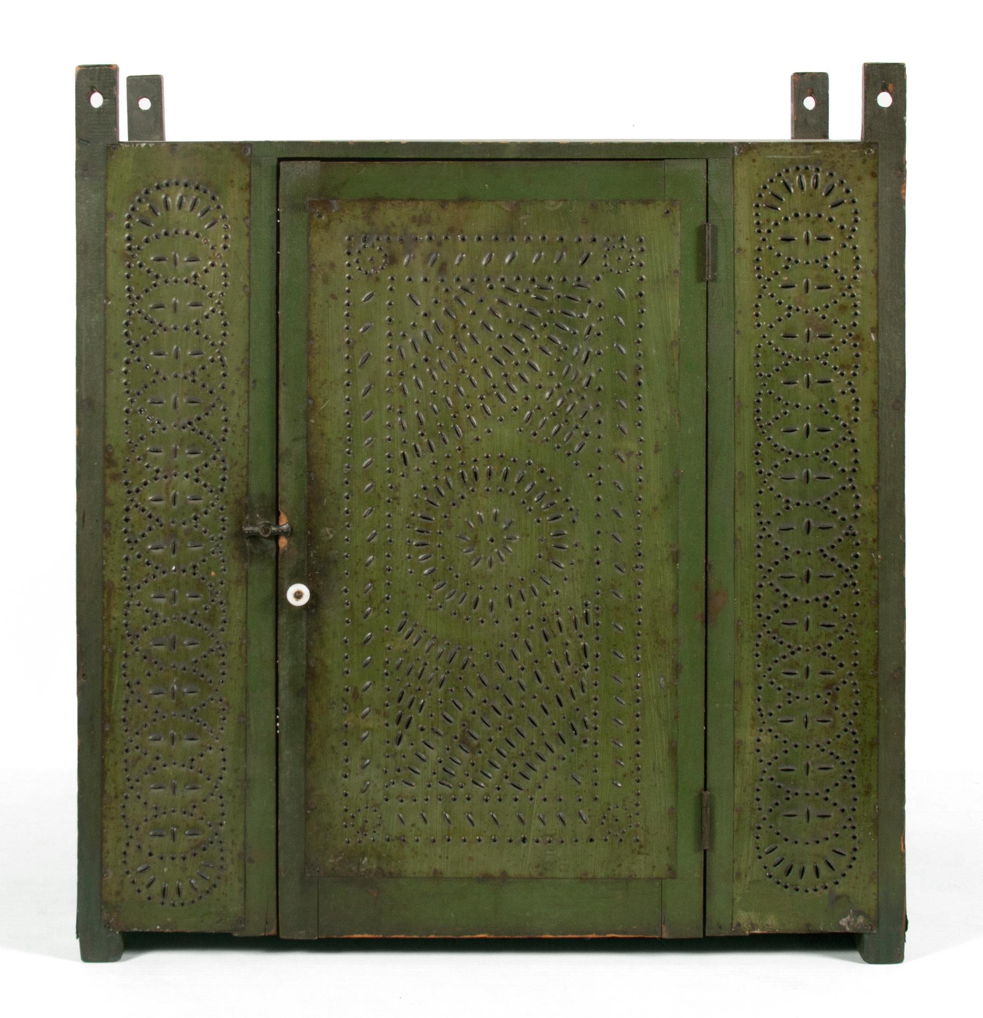 Pennsylvania hanging pie safe, in first surface green paint, with circular medallion and opposing fan decoration, circa 1850-1880

Pennsylvania hanging pie safe, made circa 1850-1870’s, with wonderfully punched tins that have a myriad of