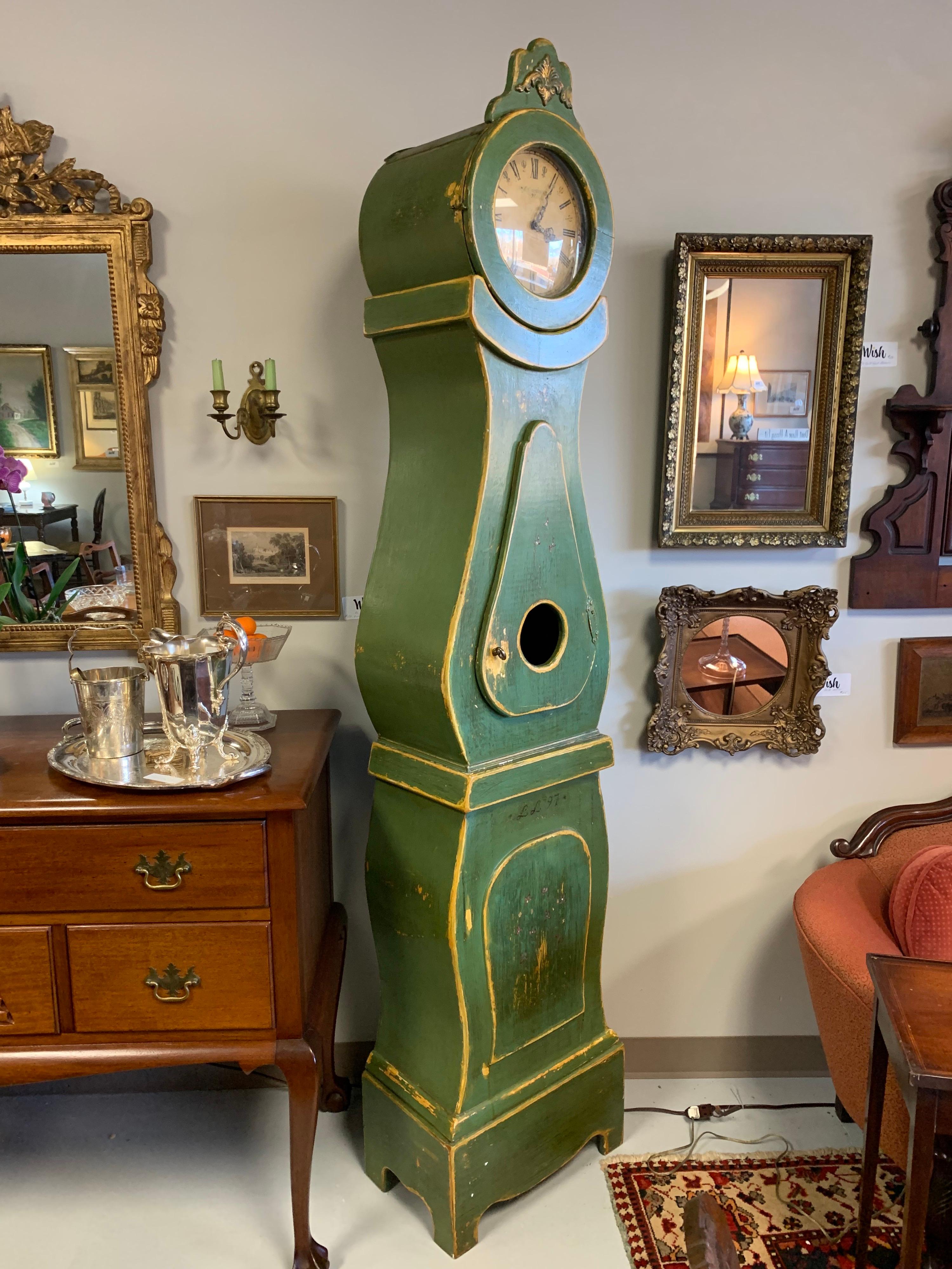 Green painted replica of an antique Gustavian Mora clock, a type of longcase clock. The name comes from the Swedish town of Mora where the clocks were made beginning in the late 1800s. This replica was hand crafted and handpainted by Swedish