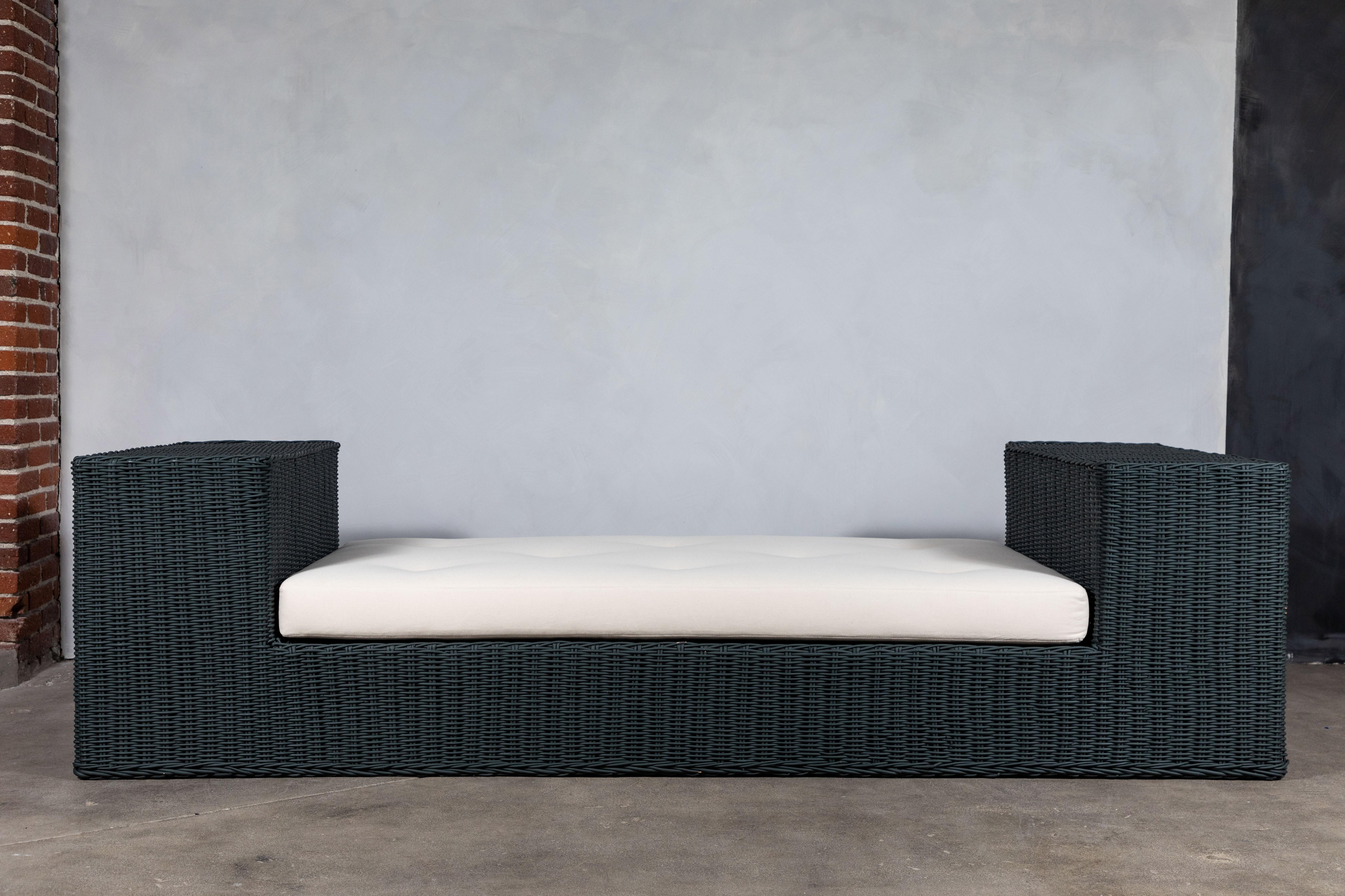 Newly Painted in Farrow and Ball Studio Green, wicker daybed. The daybed offers a large arm which can be used for sitting our serving. Newly constructed cushion with tufted pull tucks.