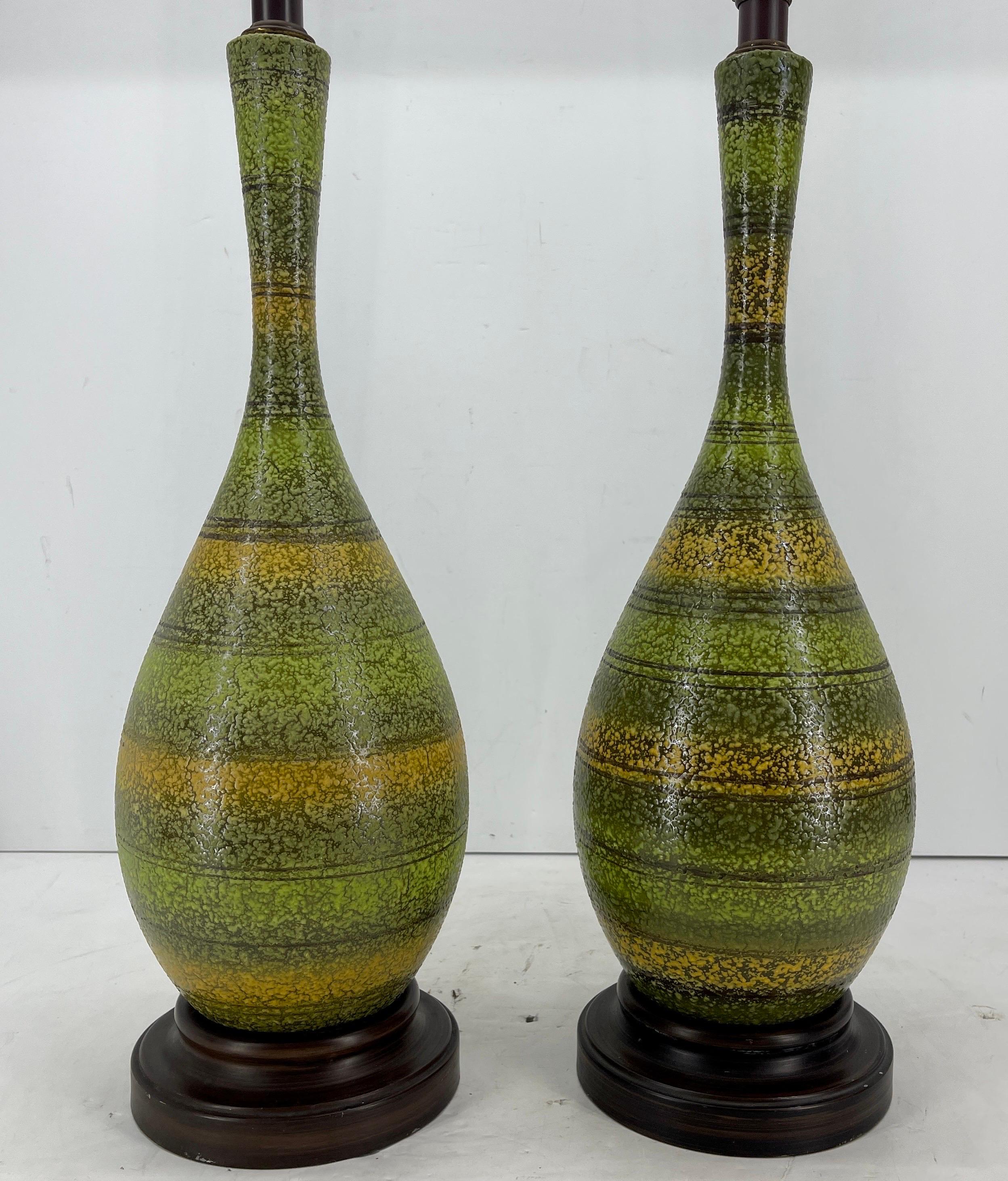 Mid-Century Modern Pair of Green Yellow Striped Textured Table Lamps

Very versatile pair of ceramic lamps in several shades of green as well as yellow exemplifying the mid-century time period. The bases of the unique lamps are metal. Perfect