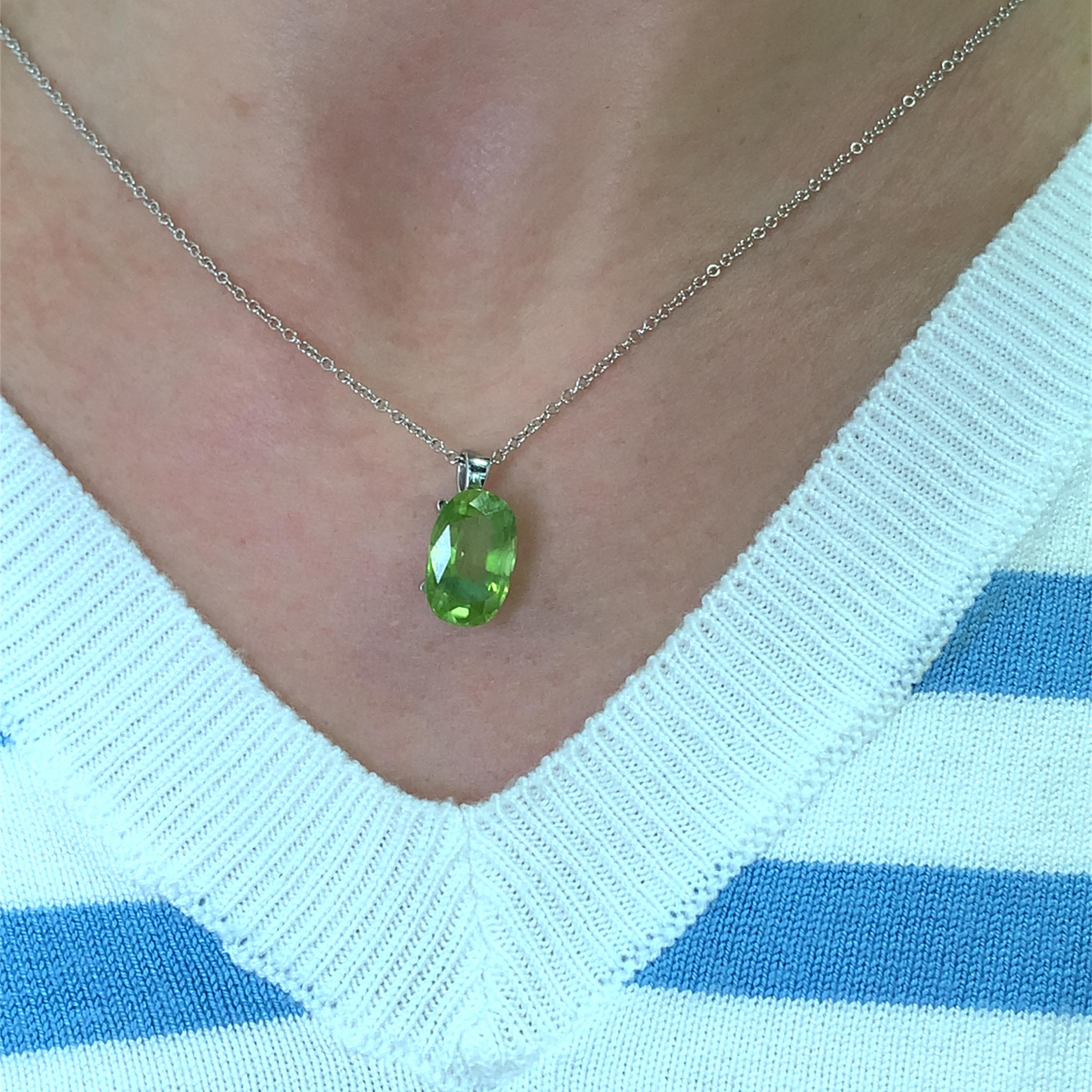 This stunning green peridot 5.05ct gemstone pendant is a true statement piece. Crafted with precision, it features a vibrant oval-cut gemstone measuring approx 13/9mm that catches the light beautifully. The delicate 18k white gold chain 16 inches 