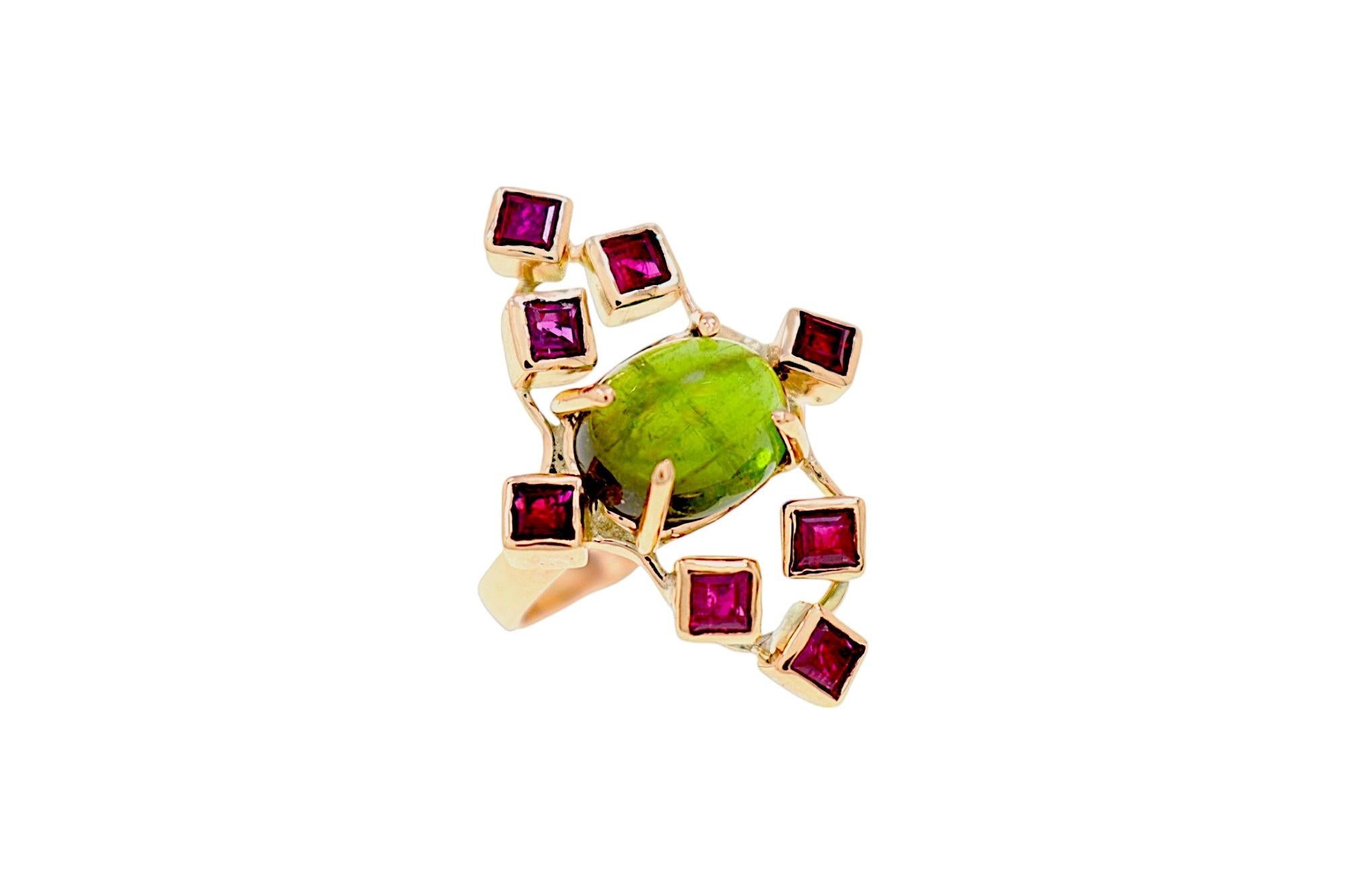 Élégante bague en or rose 9k réalisée à la main dans notre atelier de joaillerie de Milan, mettant en scène 8 rubis de taille carrée sertis dans des cubes en or massif qui entourent un péridot ovale taillé en cabochon, formant une grande navette qui