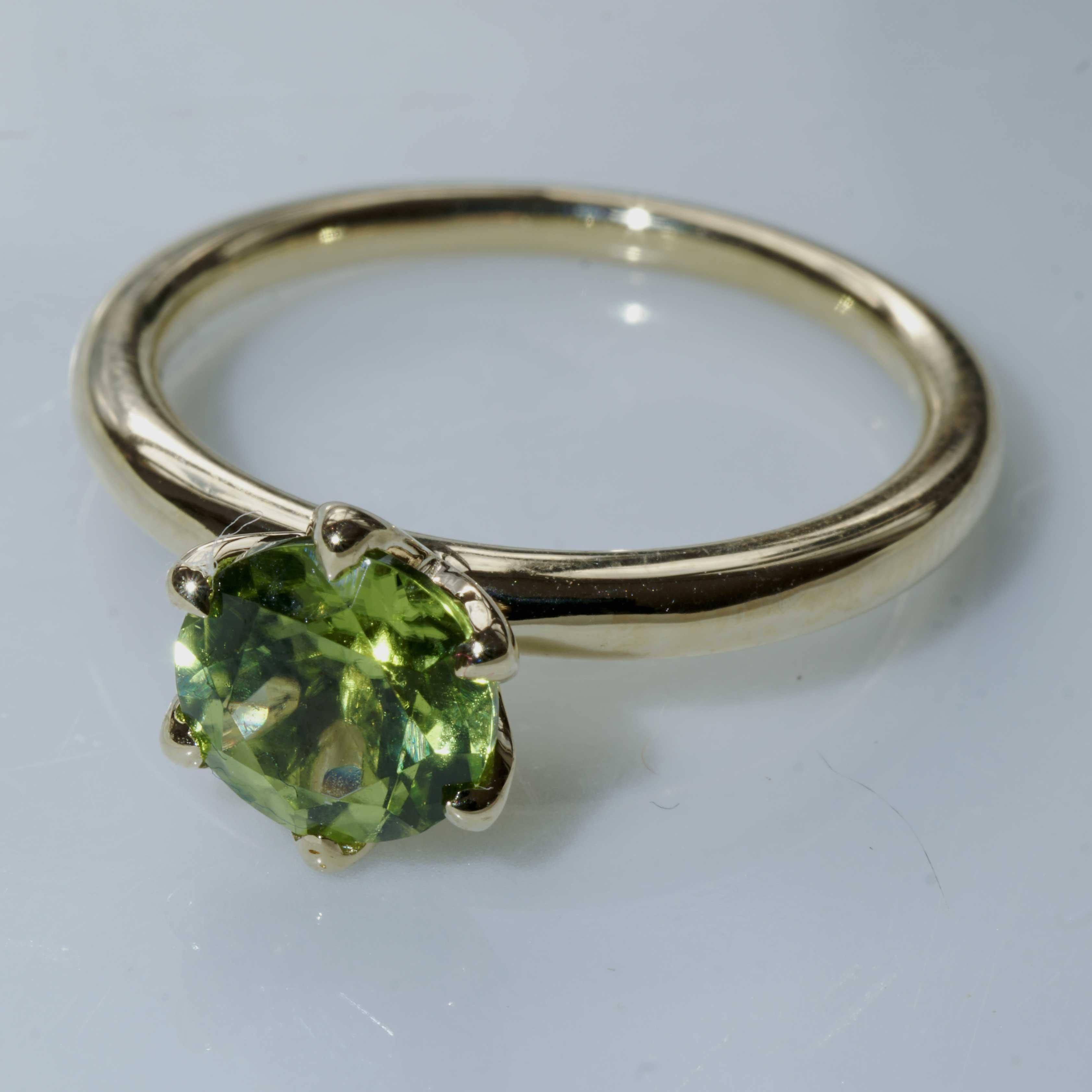 finest goldsmith's work from Italy, combination ring with a round faceted peridot of 7 mm, approx. 1.44 ct, great brilliance, perfectly cut for a lot of brilliance, fashionable underlay made of crown-shaped loops, 6 crabs, fashionable round band, 2
