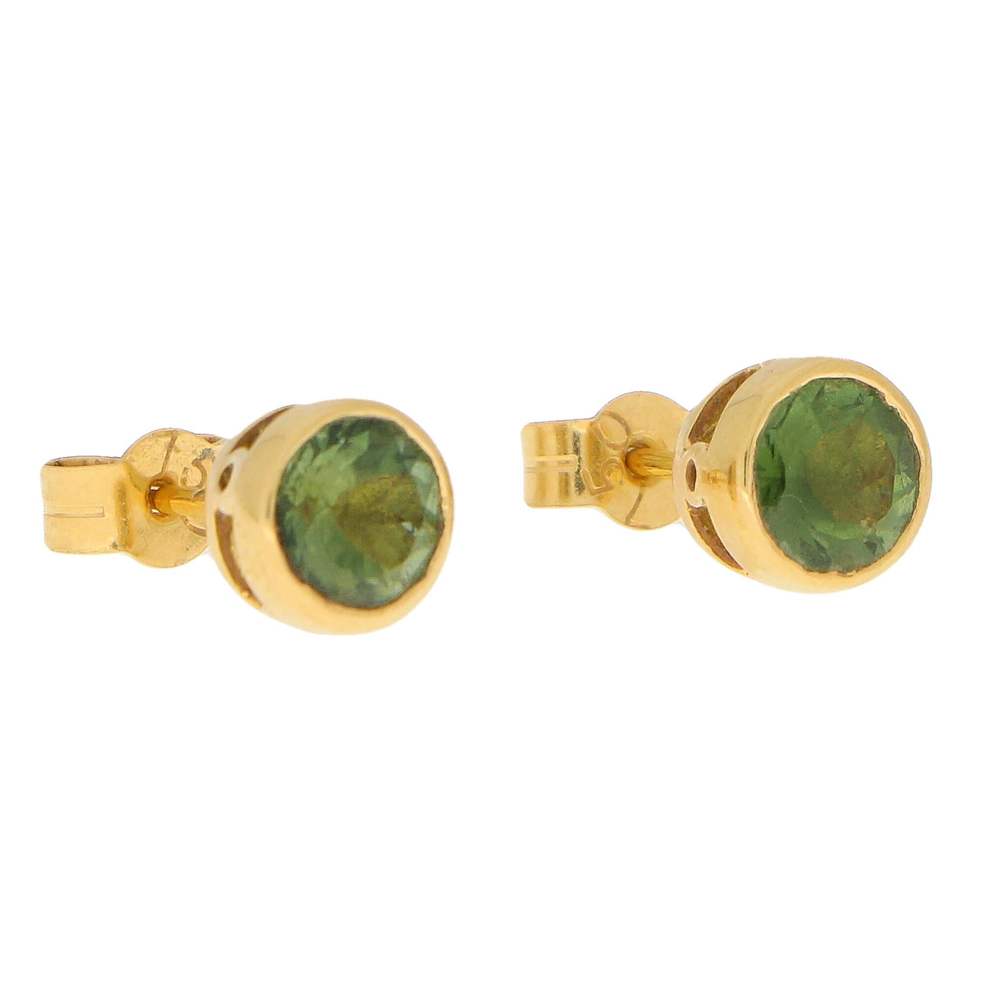 A lovely pair of green peridot stud earrings set in 18k yellow gold. 

Each earring is centrally rub over set with a round cut peridot of a lovely green colour. Each stone is set in a slightly raised openwork setting and the studs look beautiful