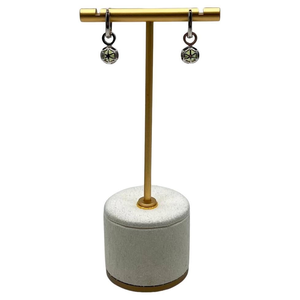 Elegant and contemporary, these exquisite drop earrings feature vibrant green gemstones encircled by shimmering white stones. The design showcases a delicate loop connecting the drop to the clasp, adding a touch of sophistication. Modern and