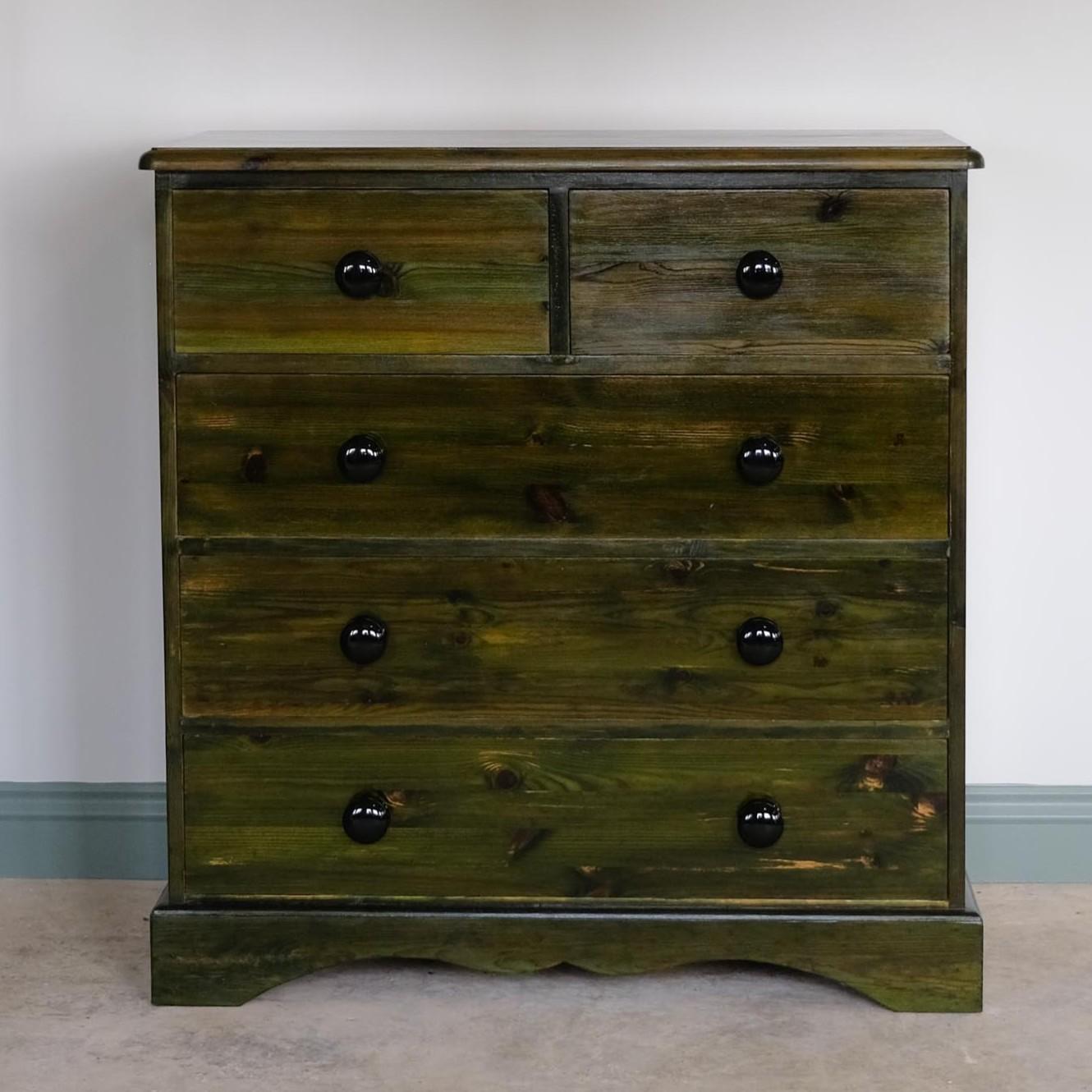 Una cassettiera d'epoca in pino, tinta di un ricco verde e con una finitura molto lucida. Due cassetti corti e tre lunghi, tutti scorrevoli e dotati di pomelli in ceramica nera. In ottime condizioni.