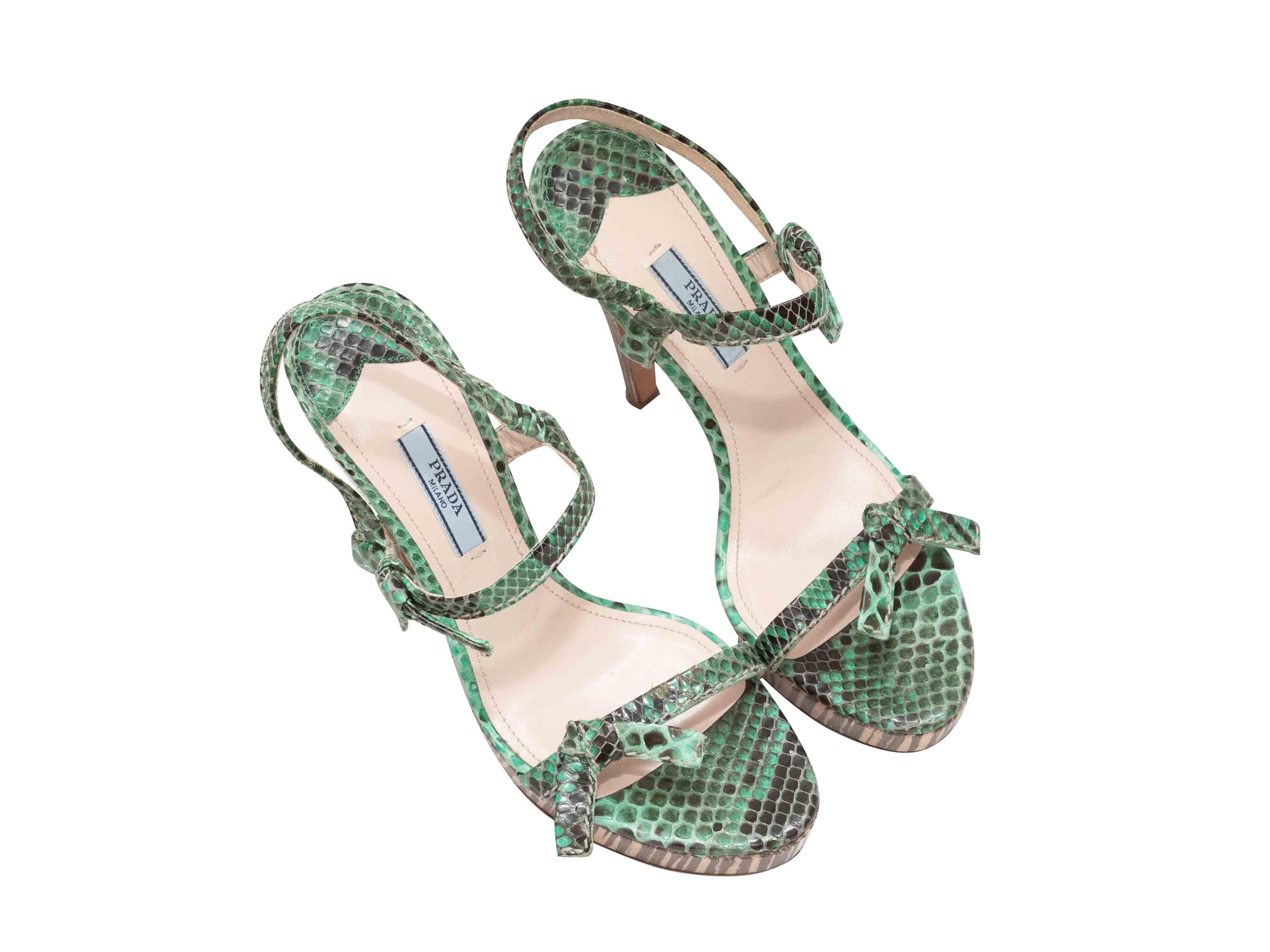 Sandali con tacco con plateau in pelle di serpente verde di Prada. Piattaforme e tacchi in legno a righe. Fiocco sulla parte superiore e sui cinturini alla caviglia. Altezza plateau 1,5