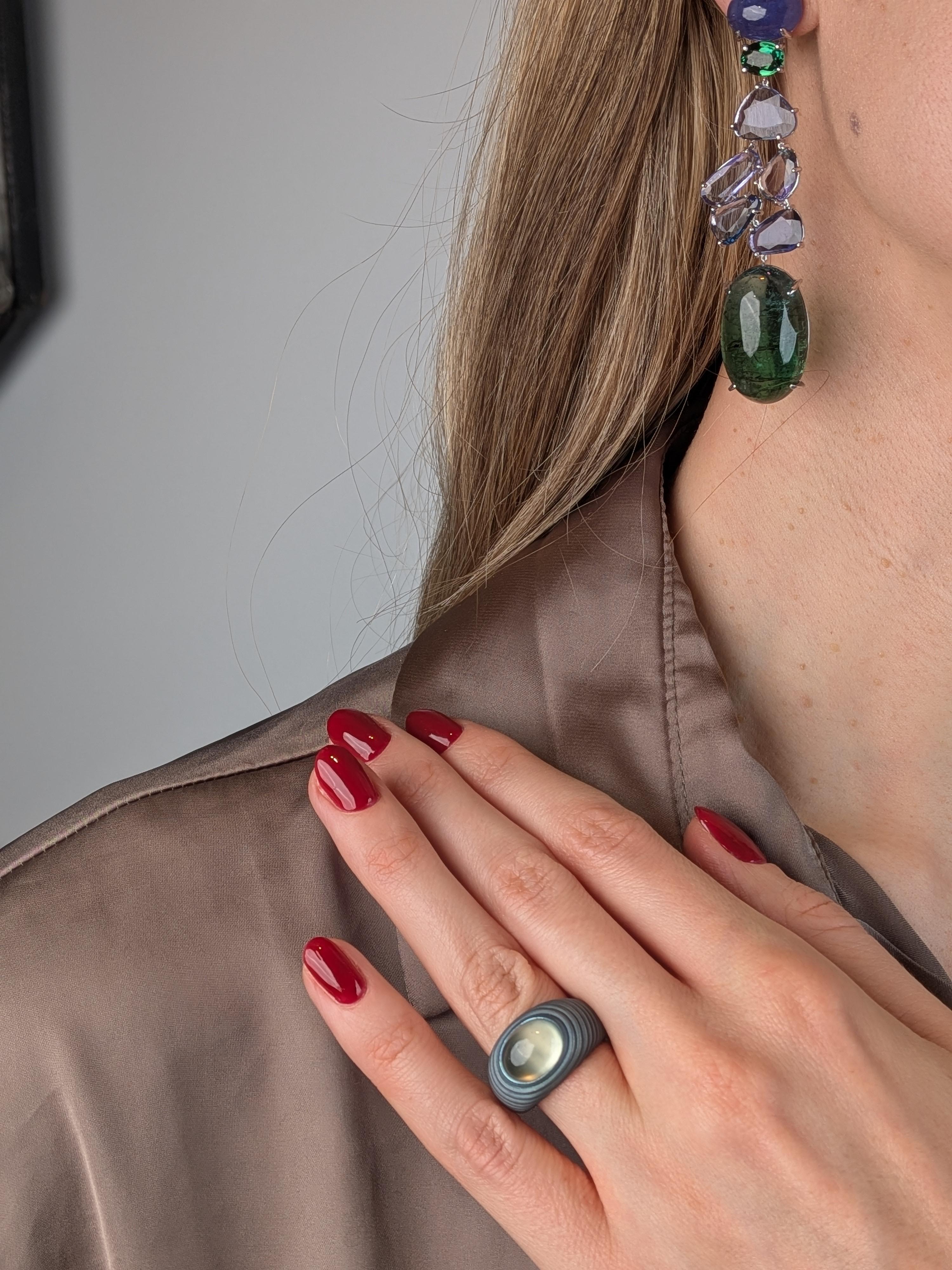 Bague en titane gris avec cabochon de Prehnite verte, dotée d'un design MXHM sculptural en couches et d'une pierre précieuse naturelle lumineuse. 

Inspirée par l'esthétique sculpturale des cabochons de René Sim Lacaze - grand-père maternel de