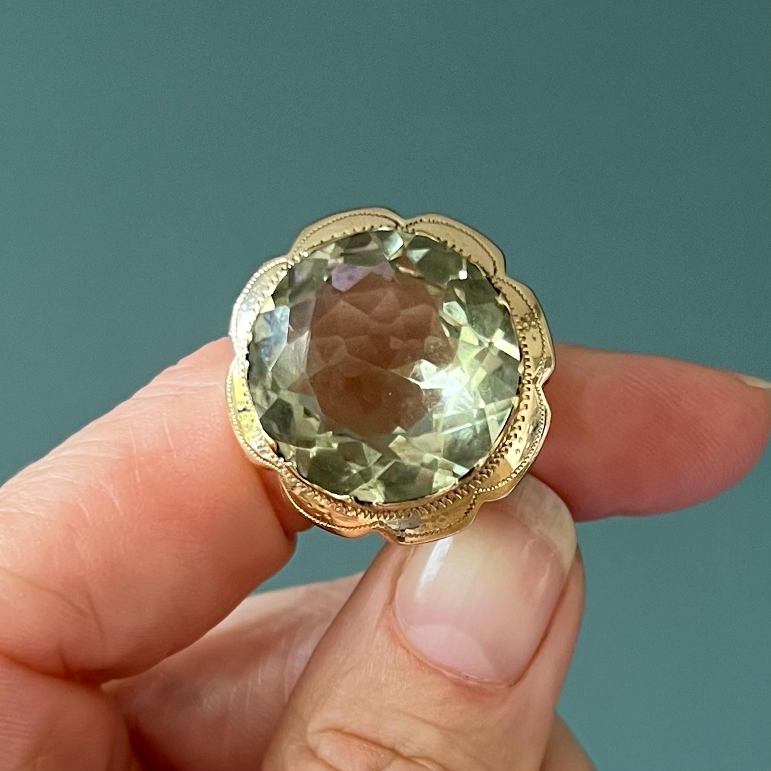 A vintage chunky 14 karat gold ring created with a green quartz stone. The gold has a lovely scalloped border with a fantasy engraved design. The quartz is just magnificent, it is very clear and bright in color. The frame of this chunky ring has an