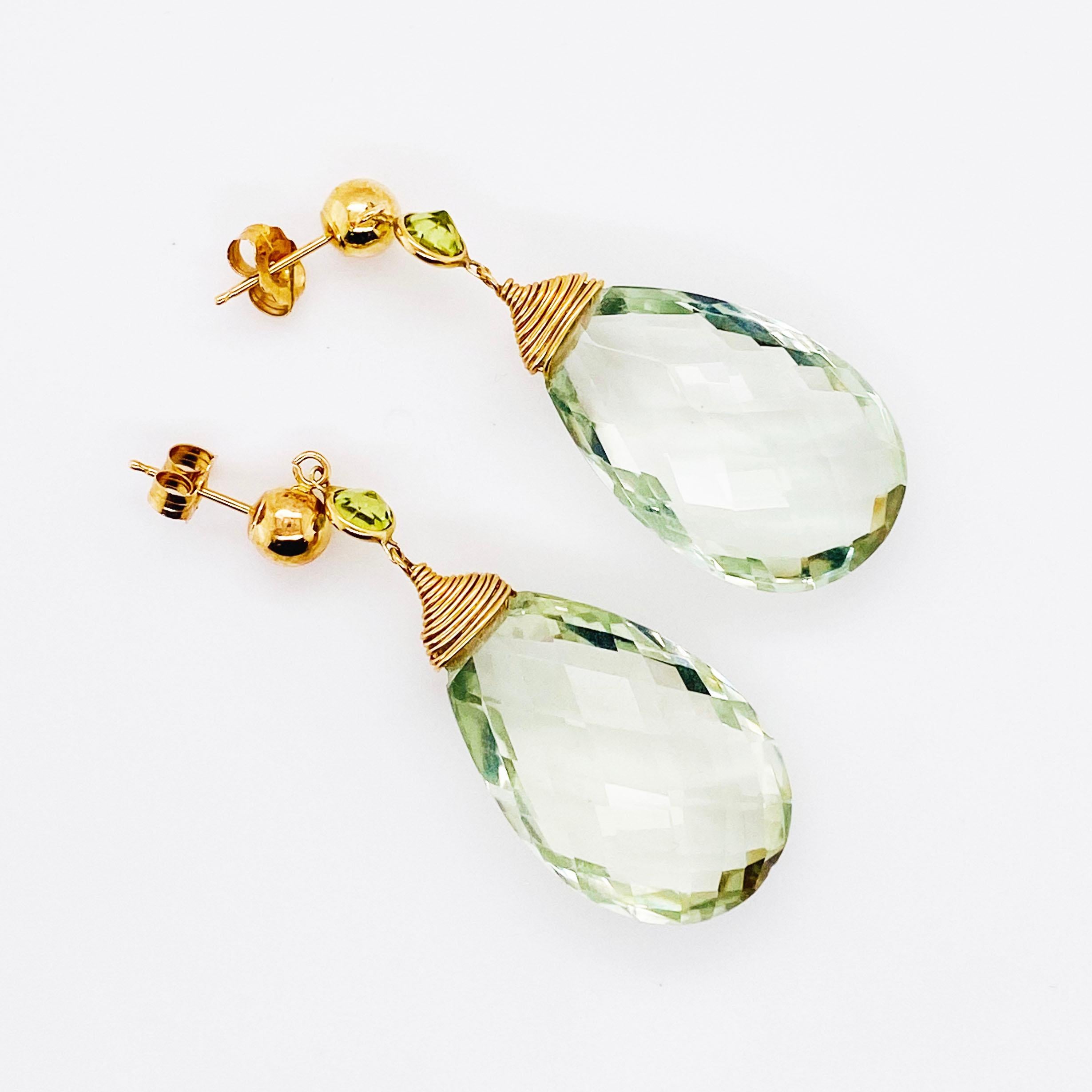 These splendid dangle earrings are real statement earrings!  There is a large briolette green quartz dangling from each earring with a bezel set green peridot above it.  The bangles are hanging from a 6 millimeter (mm) 14 karat yellow gold ball