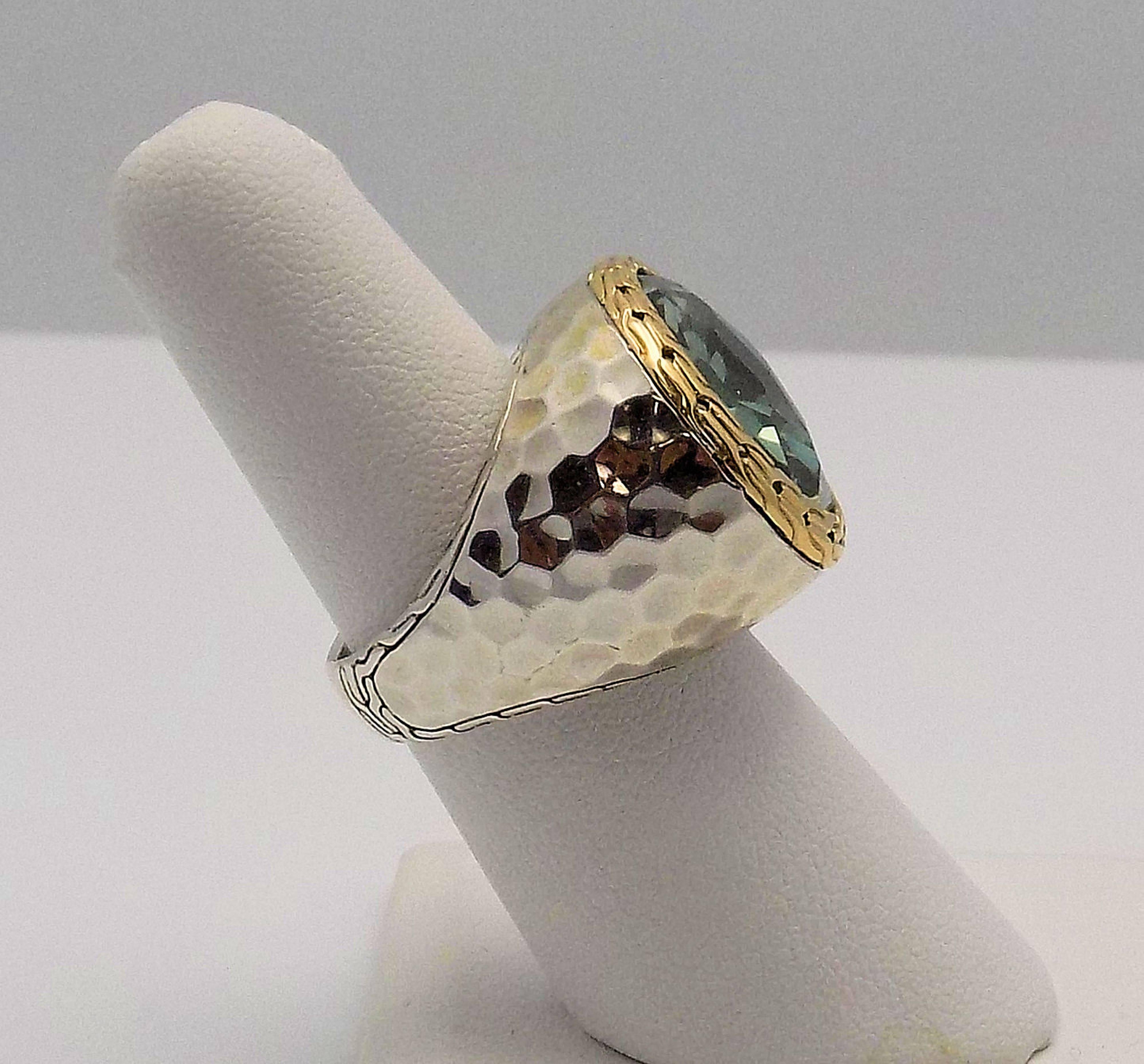 Stylish 18 Karat Yellow Gold & Sterling Silver Hammered Ring Featuring 1 Oval Checkerboard Green Quartz Which Measures 18 X 16 MM. Finger Size 7.5 Signed: John Hardy. With Polishing Cloth and John Hardy Pouch. 11.0 DWT or 17.11 Grams.