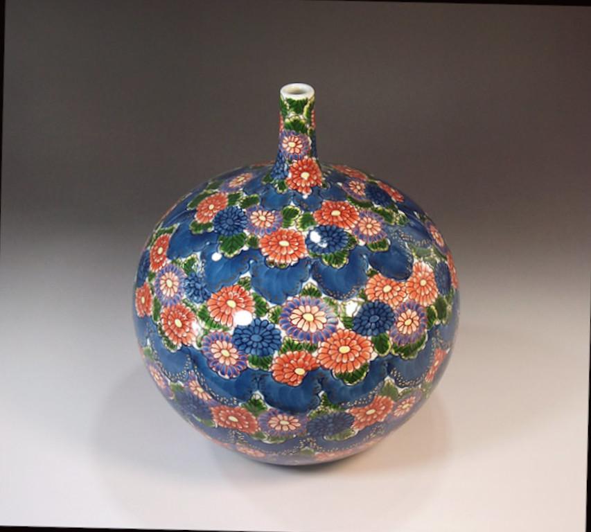 Elegant gilded contemporary Japanese porcelain decorative vase hand painted in red, blue, purple and green on an elegant bottle shape body, a signed work by widely acclaimed Japanese master porcelain artist in Imari-Arita tradition of Japan, and