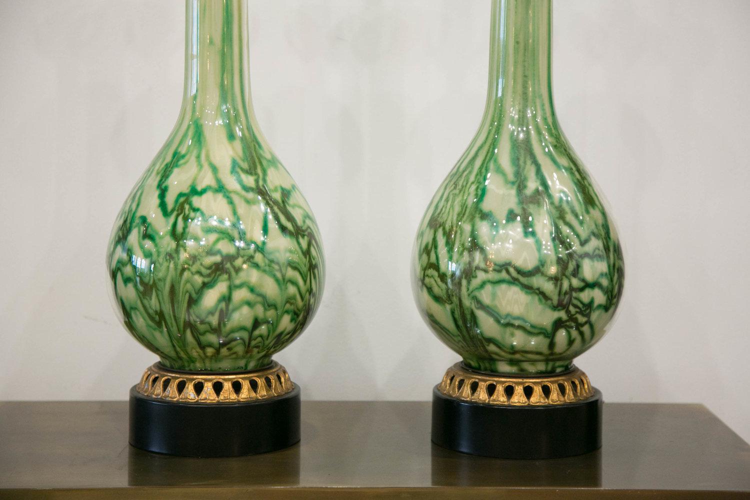 A stunning tall pair of reverse painted glass lamps with a marbleized effect in emerald, olive, and light greens. These remind us of marble or malachite! The decorative gilded trim along the lamp base is a beautiful detail. These lamps have been