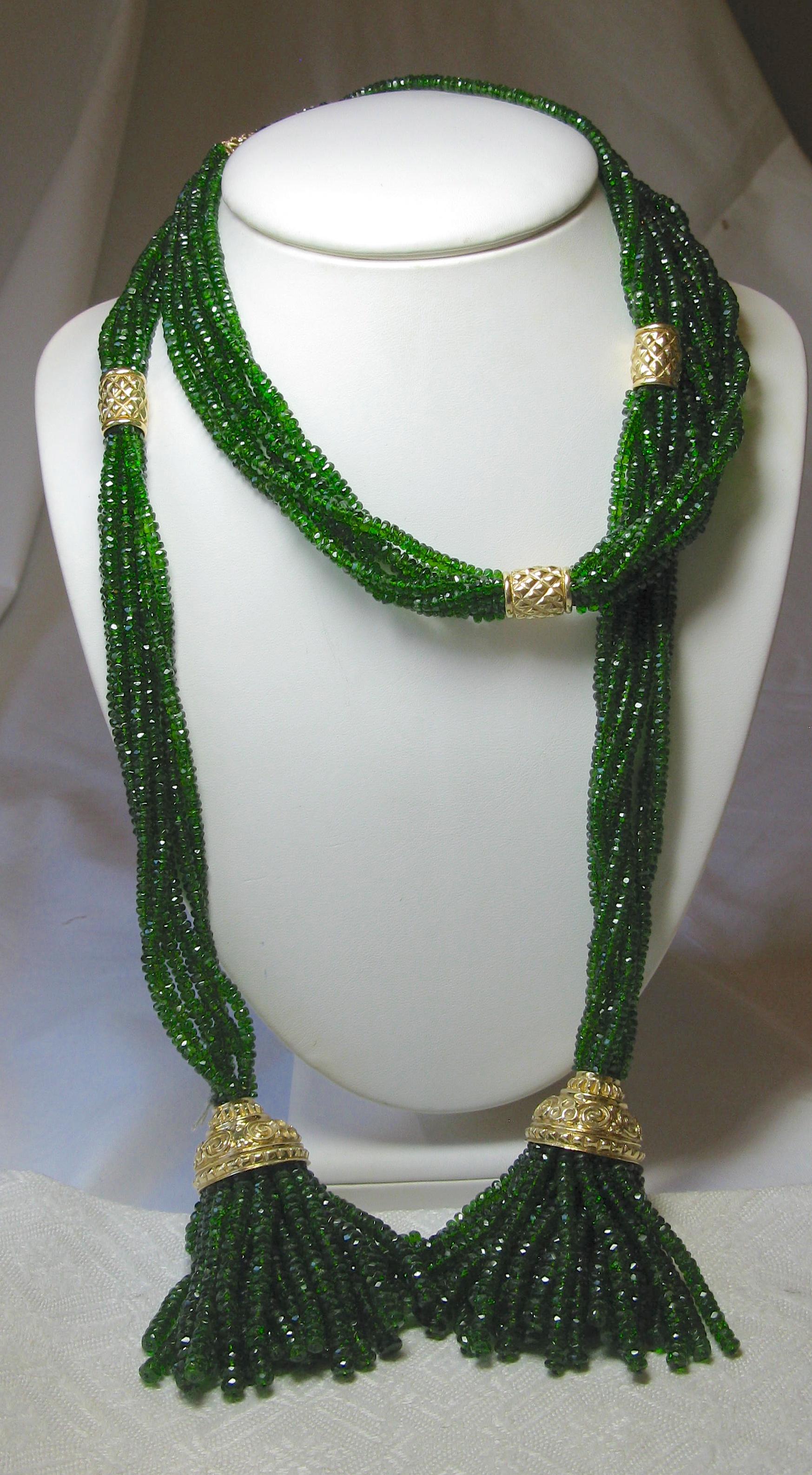 Seven Strands of spectacular Green Sapphires, 44 inches in length, are set with 14 Karat Gold rondelles to create one of the finest Lariat Tassel Necklaces we have seen.  The dramatic length, the stunning vivid green sapphires, and the warm 14 Karat