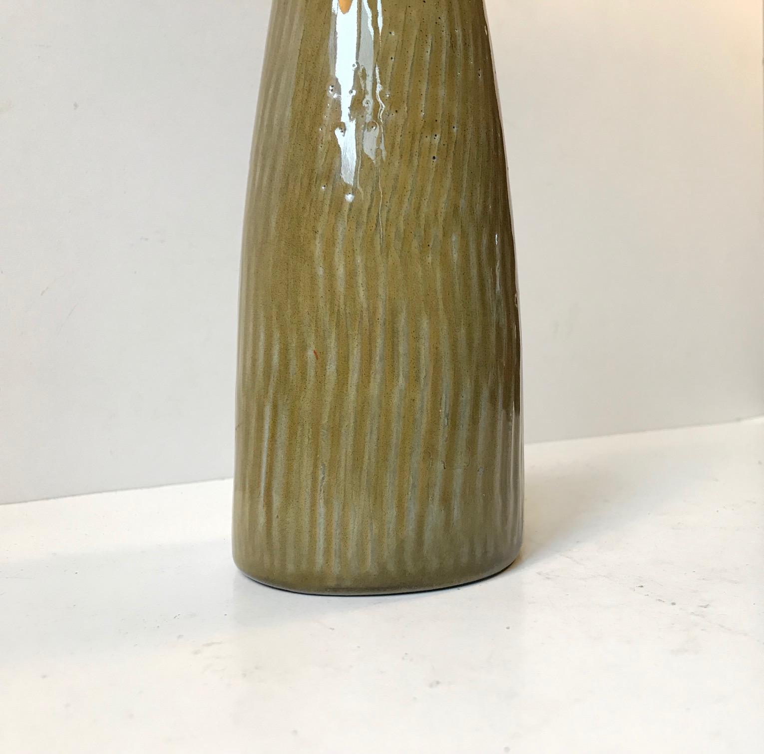 Questo vaso in gres con smalto verde oliva è stato disegnato dal ceramista svedese Gunnar Nylund e prodotto da Boveskov, Danimarca. È stato prodotto negli anni '60 e presenta un marchio di fabbrica scritto a mano sulla base. Misure: H: 21, P: 7,5 cm