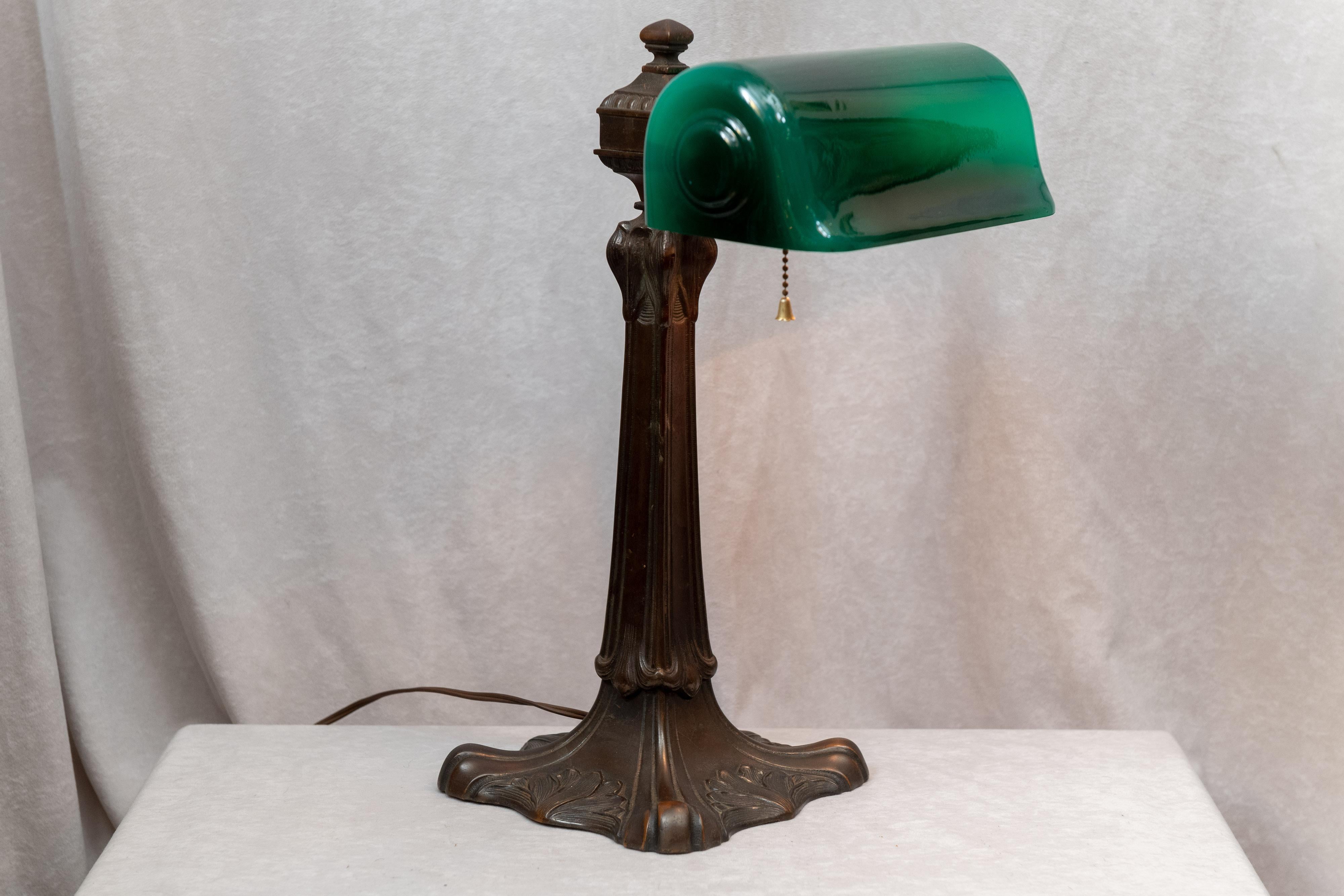 This is the desk lamp folks are always looking to purchase. Verdelite was one of the premier makers of these banker's lamps. What separates this from the general look is the unusual and wonderful art nouveau base. The base has a knuckle where you
