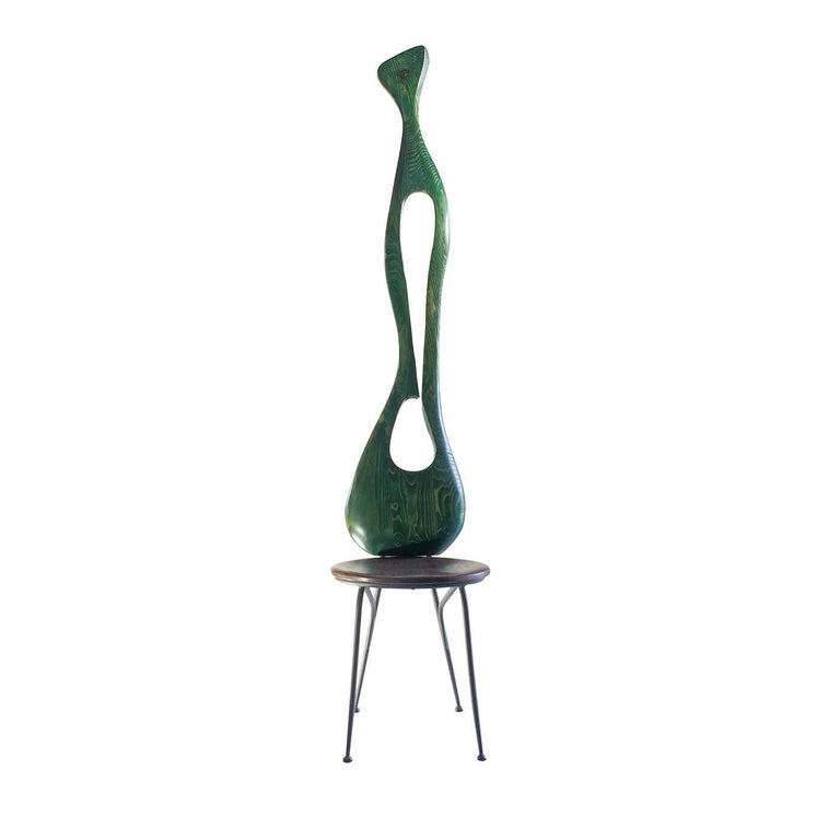Sculpture and design combine in this unique chair, revealing a visually engaging and elegant piece. The sinuous back, handcrafted of fir wood and finished by hand with water green paint, elevates vertically providing a sense of lightness to the