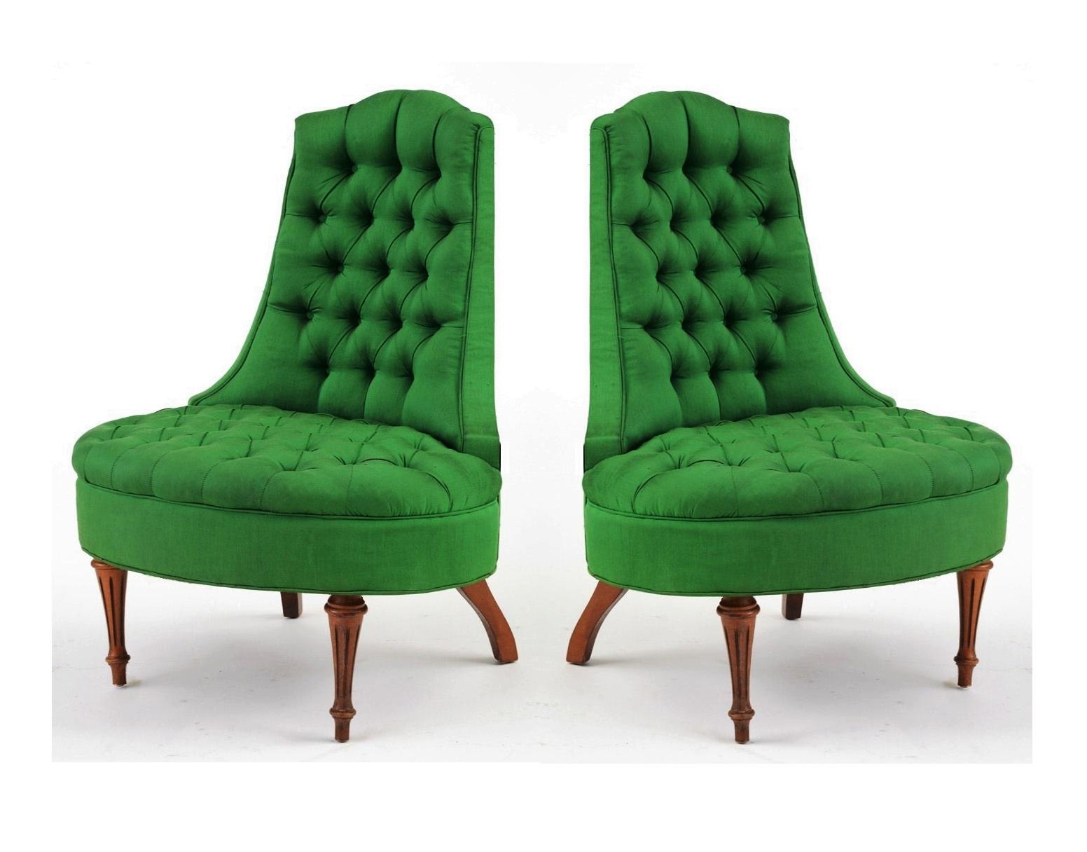 A pair of glamorous Hollywood Regency style tufted lounge chairs. The arm less chairs features a curved back, with an oval seat, standing on reeded front legs. The chair is upholstered in a fresh green silk fabric, with button tufting to back and