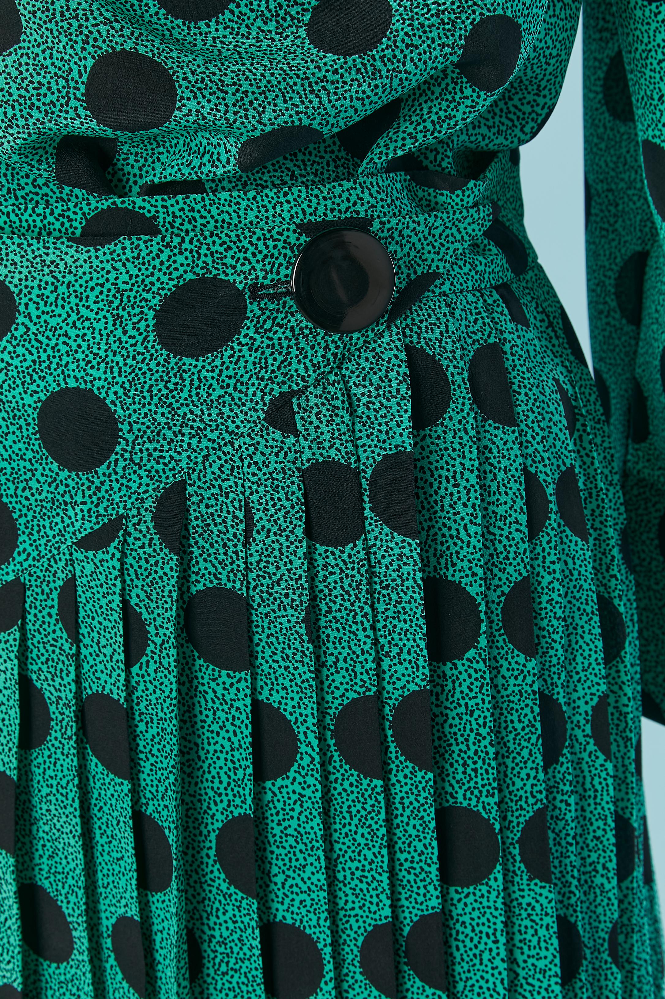 Green silk with polka dots pattern top and skirt ensemble. Shoulder pad. Button and buttonhole on the cuffs and one button with buttonhole on the left shoulder + bow. 
Pleated skirt. 
SIZE 38 (Fr) M ( and M/L for the shirt) 
