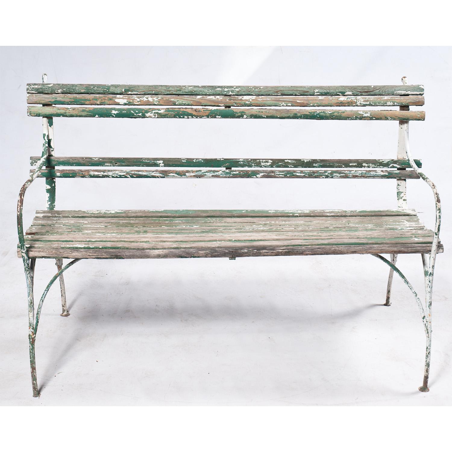 Vintage green and white slatted garden bench from the 19th century. Wooded bench has a beautiful patina and graceful metal arms and legs. Vintage condition.
 