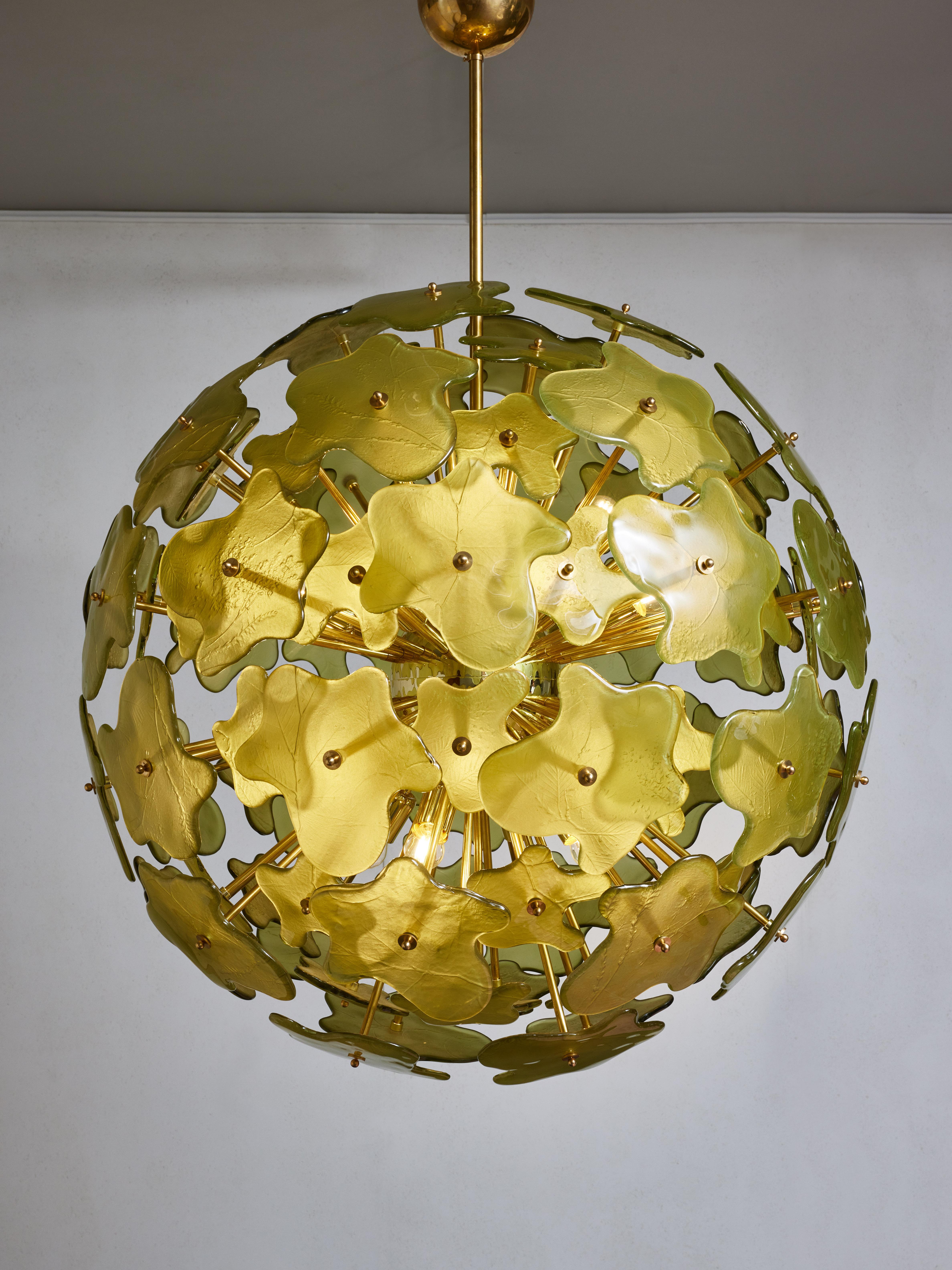 Lustre classique de forme ronde composé d'une structure en laiton avec vingt-quatre lumières, recouvertes de pièces de verre de Murano en forme d'éclaboussures. 