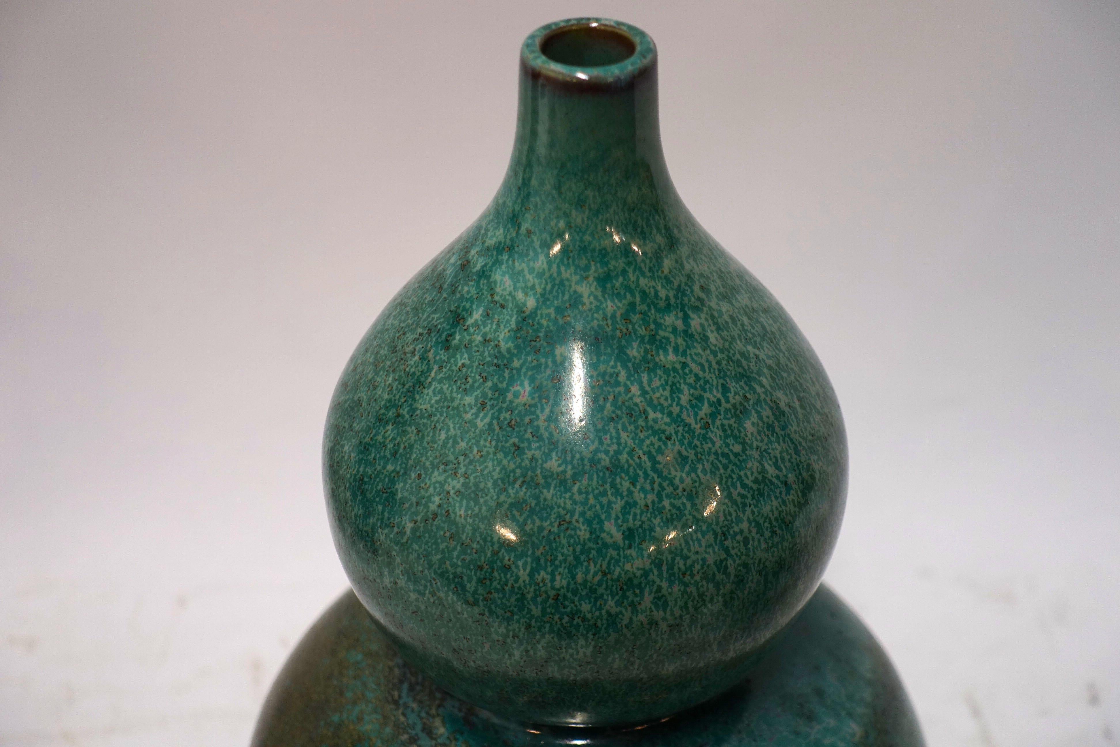 Contemporary gourd shaped vase with a green splatter design glaze.
 