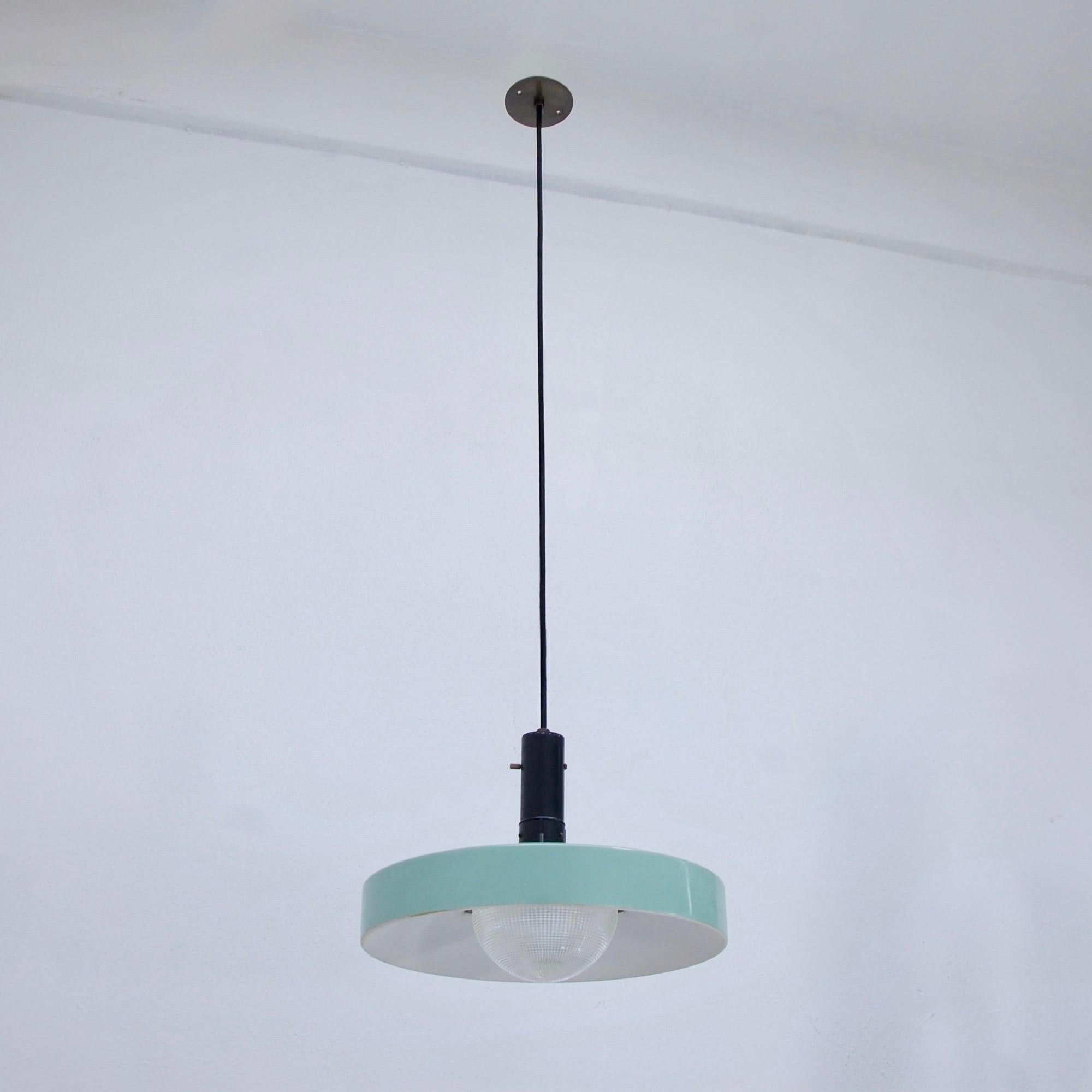 1950s, modern and sleek green industrial pendant by Stilnovo of Italy. Painted aluminium, holopane glass, painted steel and brass. Two small blemishes on glass (see image) but no cracks. Single E26 medium based light socket. Overall drop adjustable.
